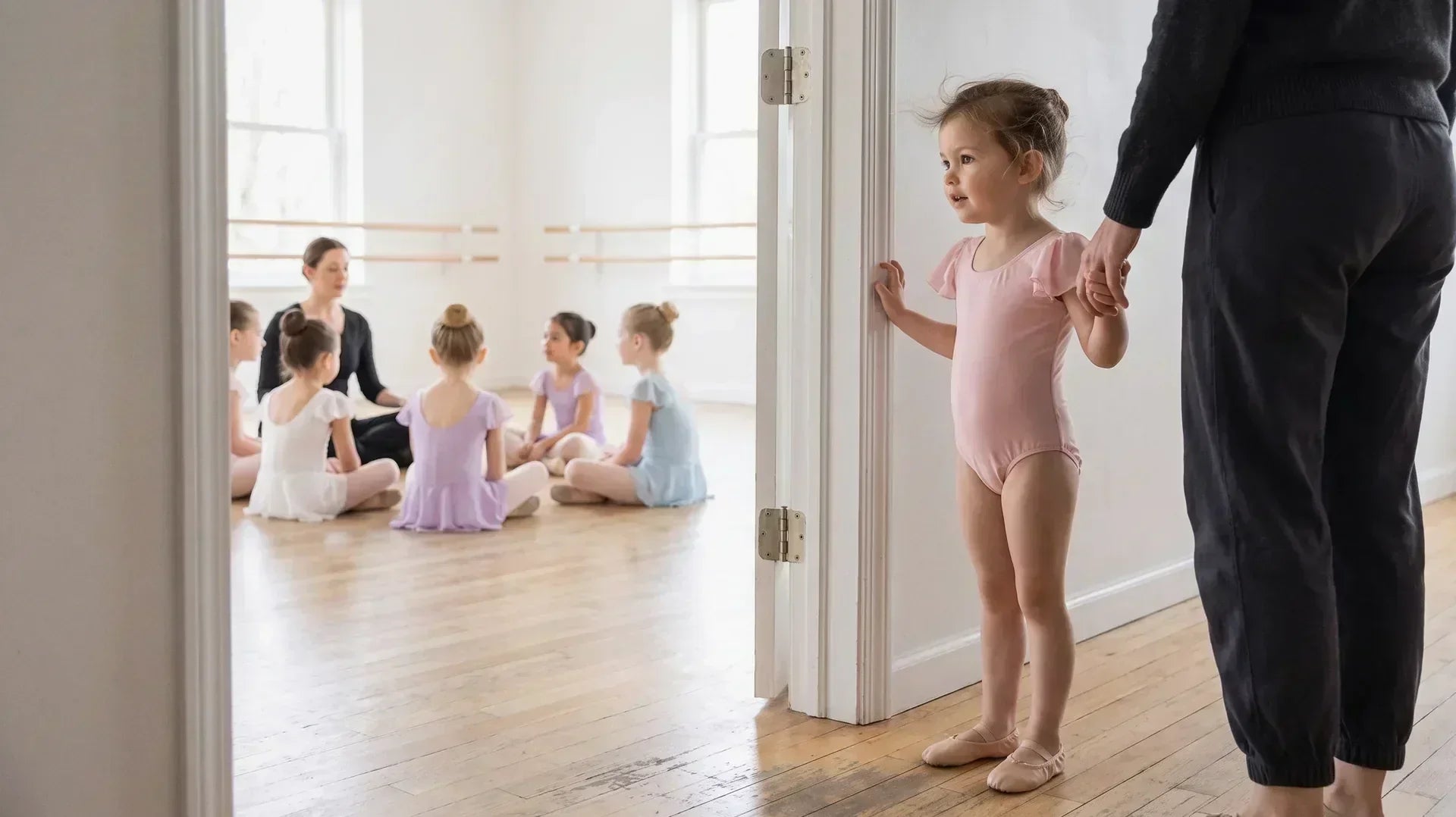 Young child arriving at her first ballet class for kids with a parent