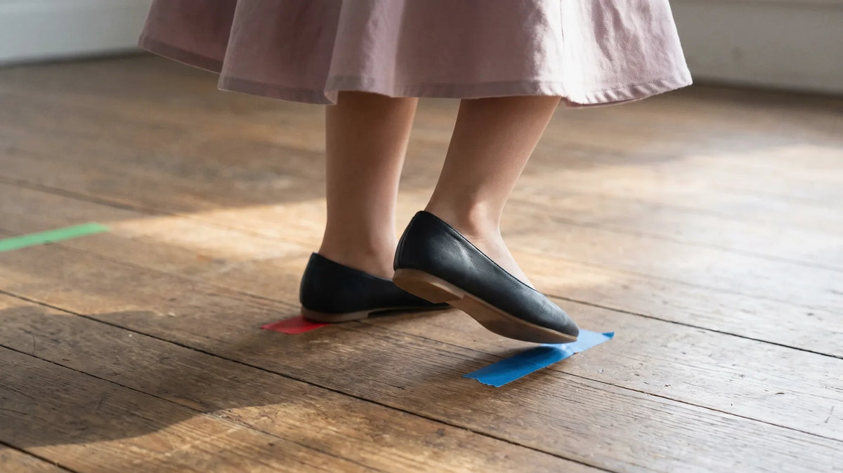 Child's feet in smooth-soled flat shoes stepping through the rock step and triple step of the basic East Coast swing