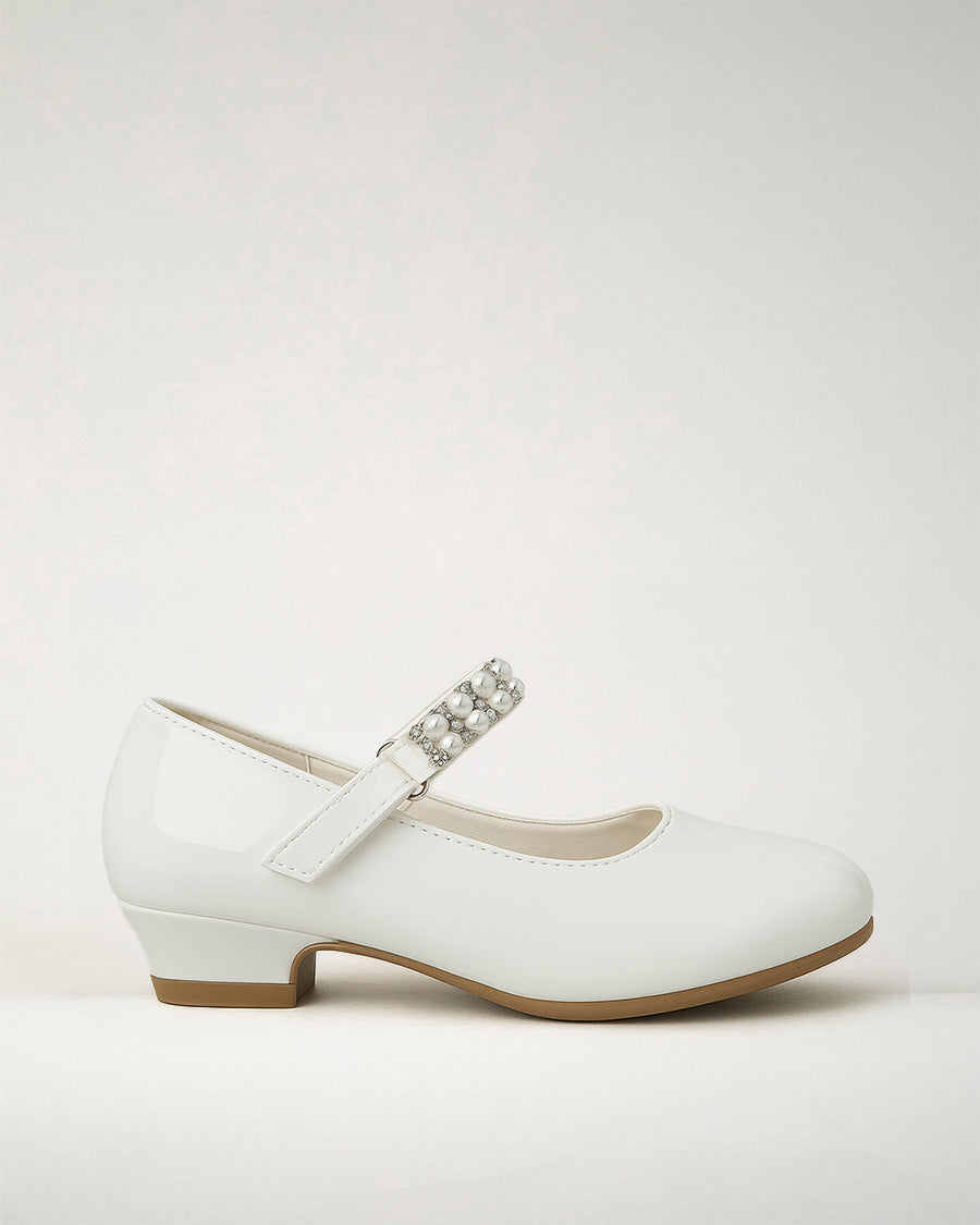 A white low heel Mary Jane dress shoe with a pearl and diamond strap on a plain background.