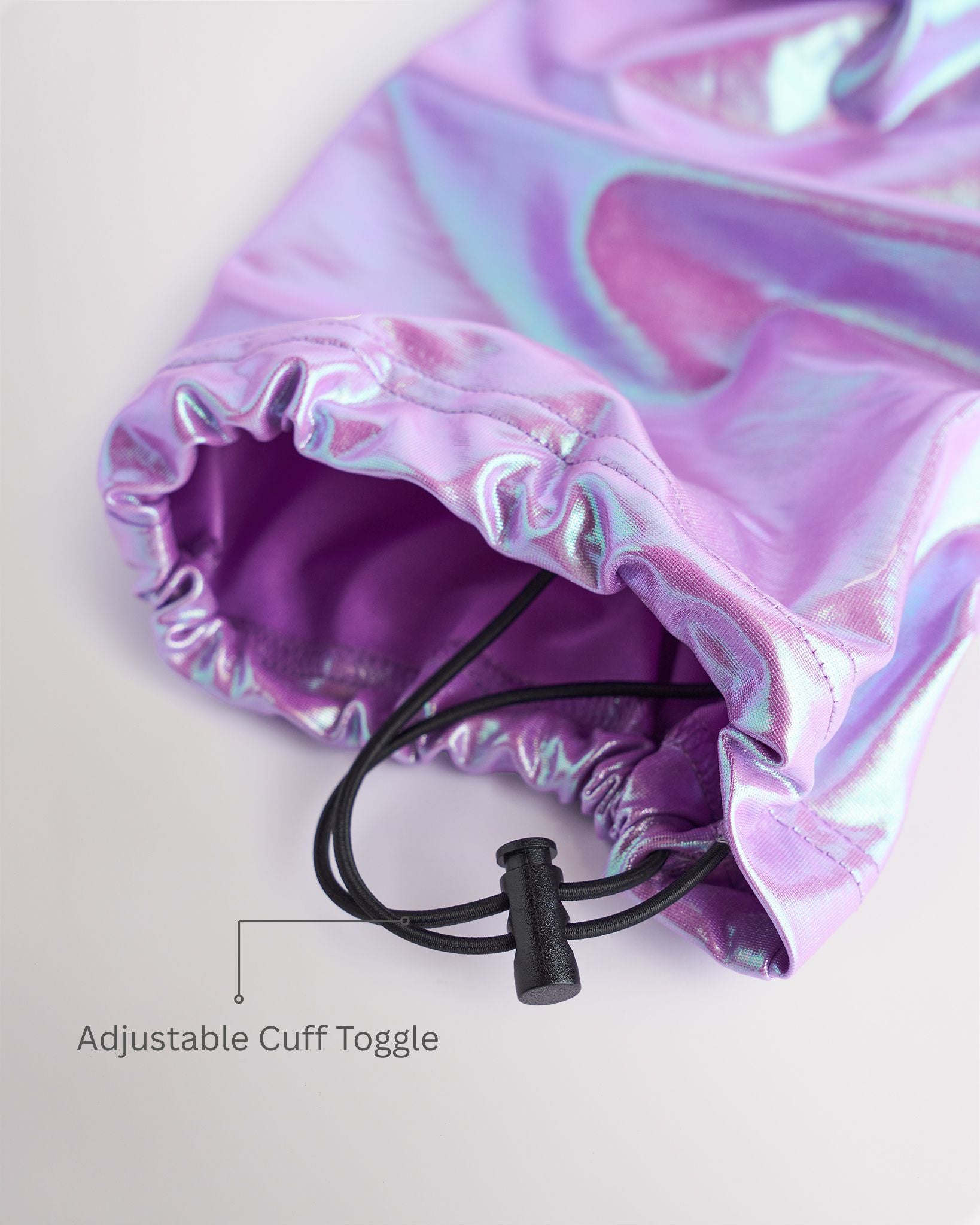 Close-up of iridescent purple girls cargo pants showing the adjustable cuff toggle at the hem for switching between wide-leg and tapered jogger styling.
