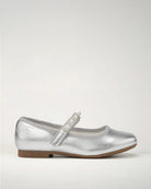 A silver ballet flat with beaded straps on a white background.