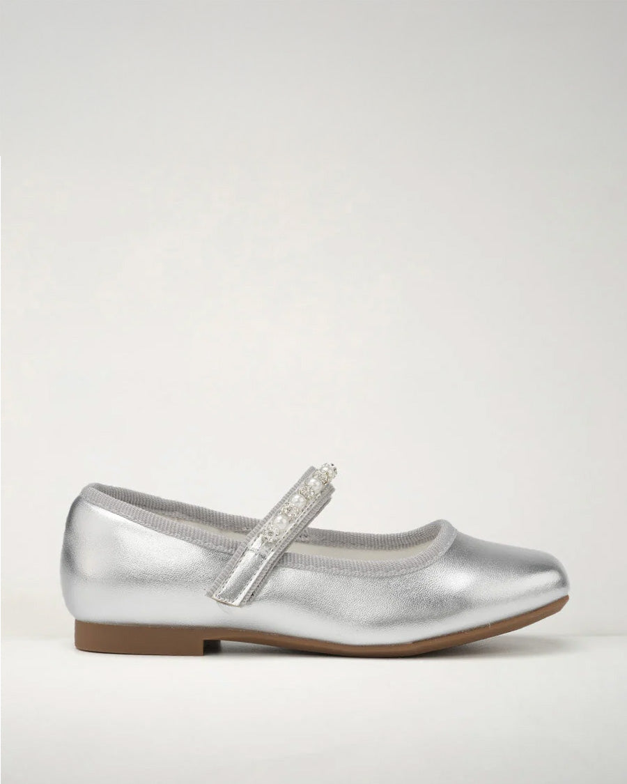 A silver ballet flat with beaded straps on a white background.
