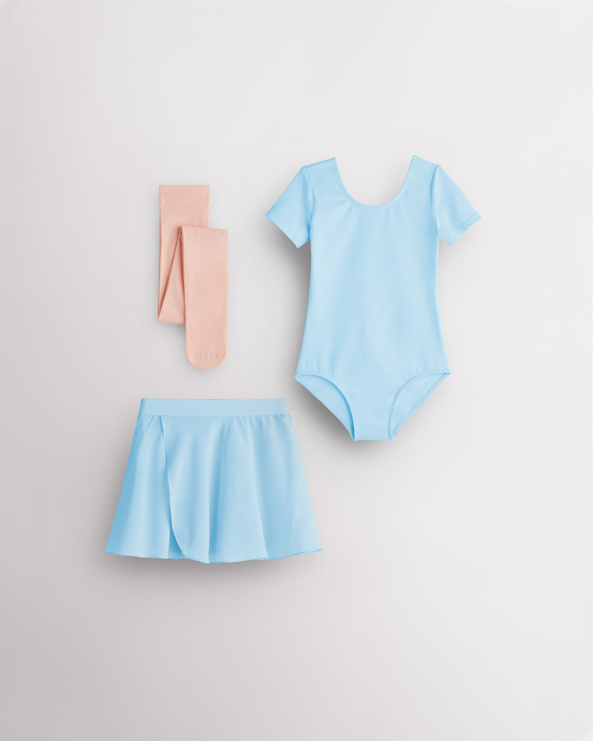 Blue girls ballet starter kit laid flat with short sleeve leotard, red chiffon pull-on skirt, and ballet pink footed tights.