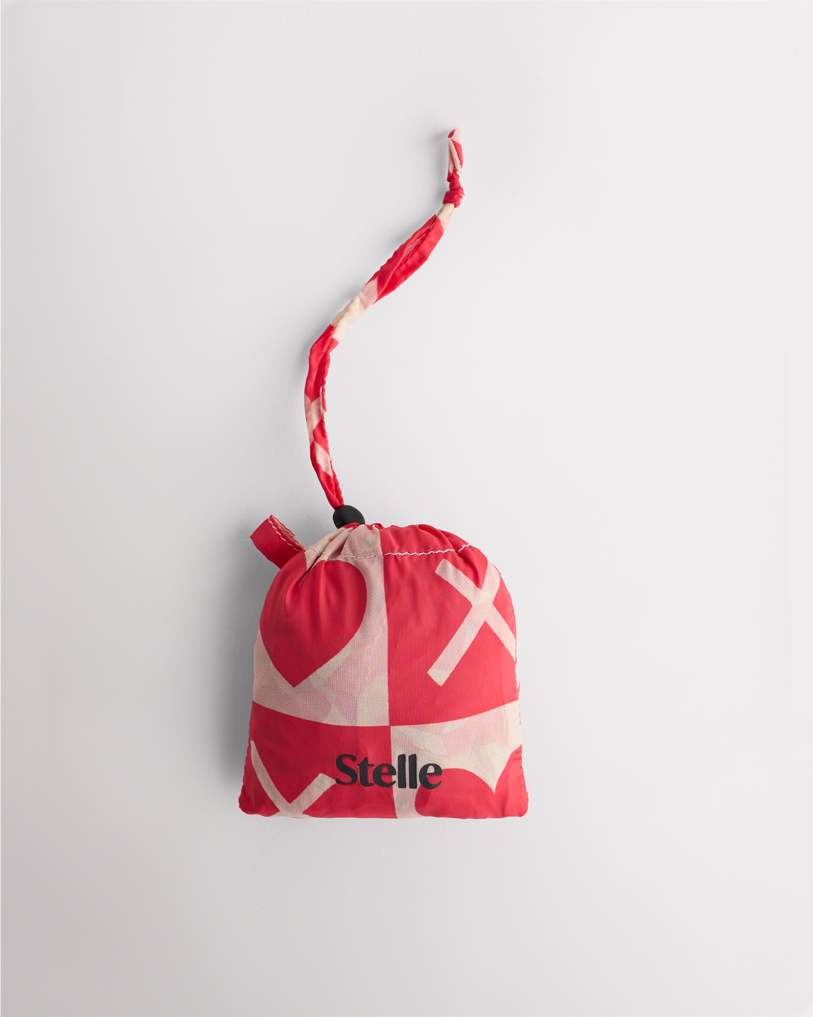 Folded Love Match Stelle reusable grocery bag in attached pouch with puppy print and clip-on loop for compact storage.