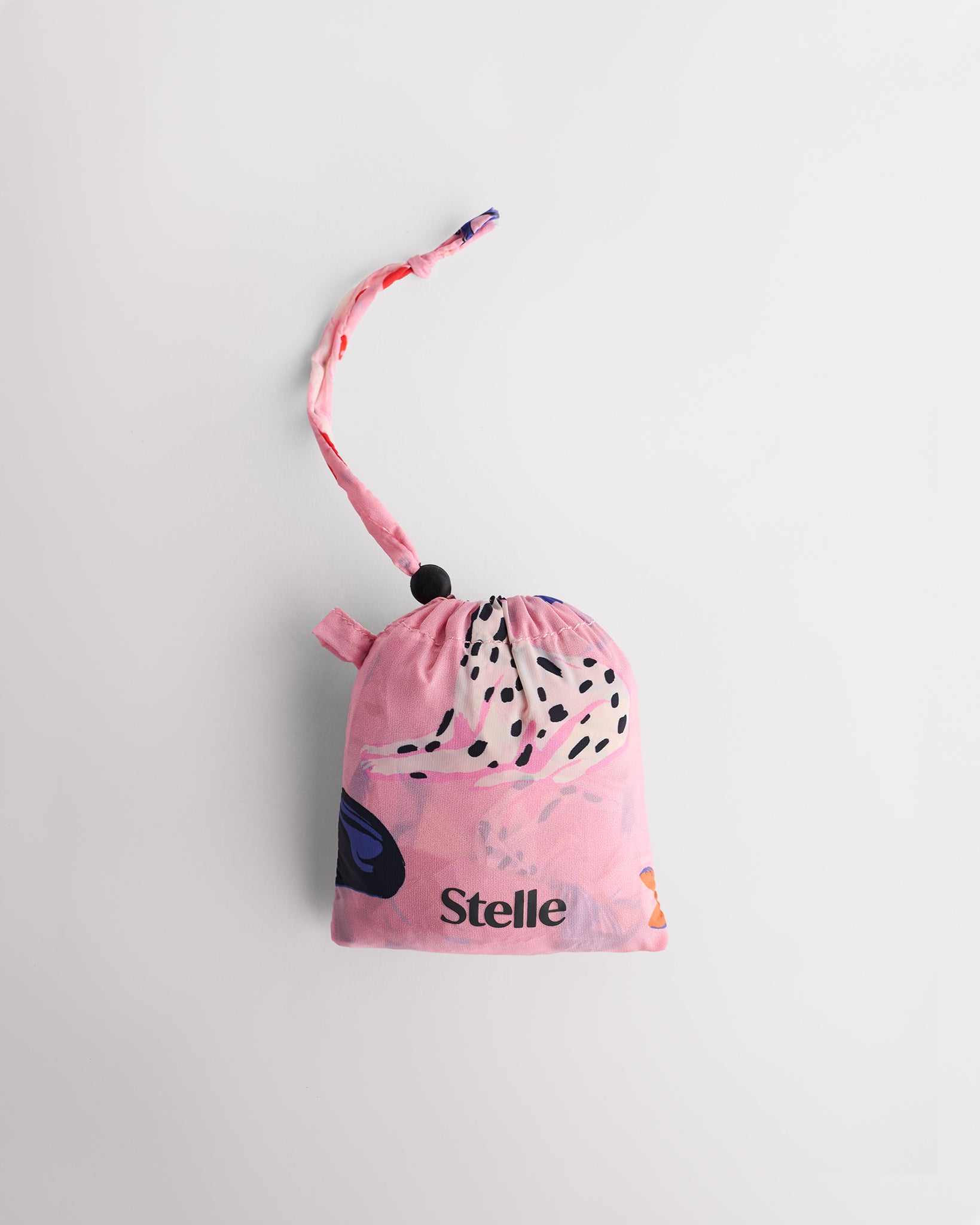 Folded Puppy Parade on Pink Stelle reusable grocery bag in attached pouch with puppy print and clip-on loop for compact storage.