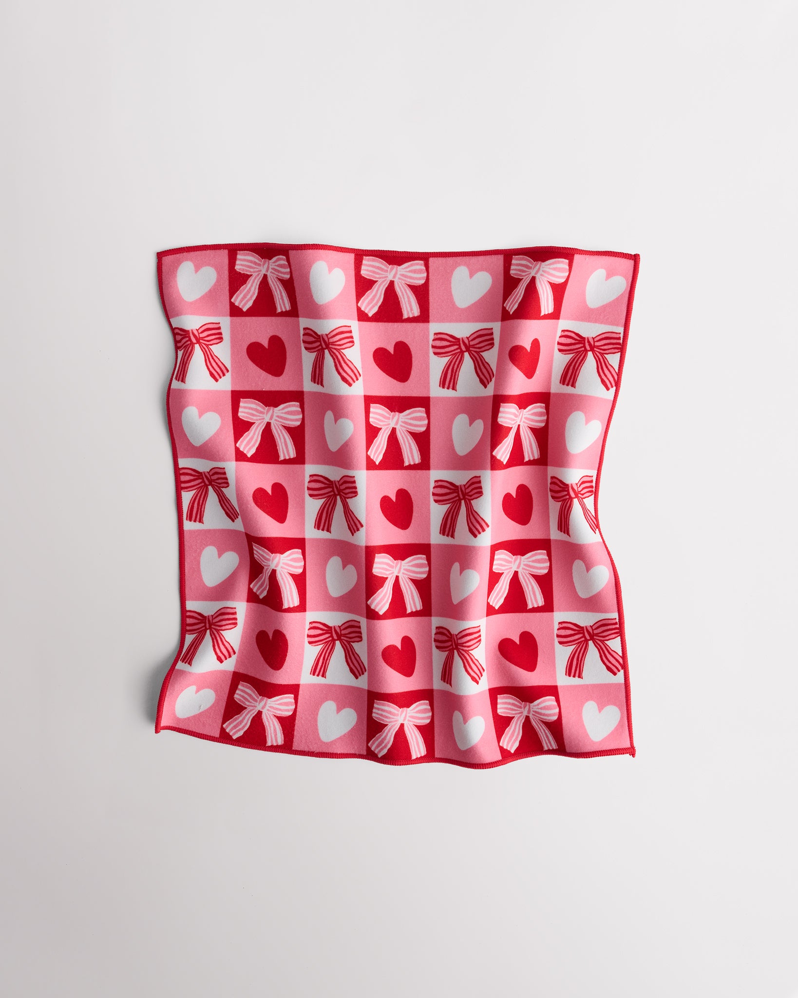 Magic Self-Adhesive Wrapper Essential Bag with red and pink heart and bow print, shown slightly folded