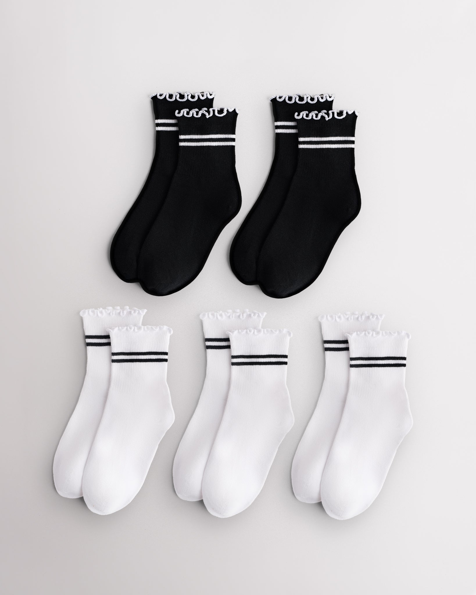 Five pairs of kids socks in black and white with sporty stripes and lettuce-edge ruffle cuffs