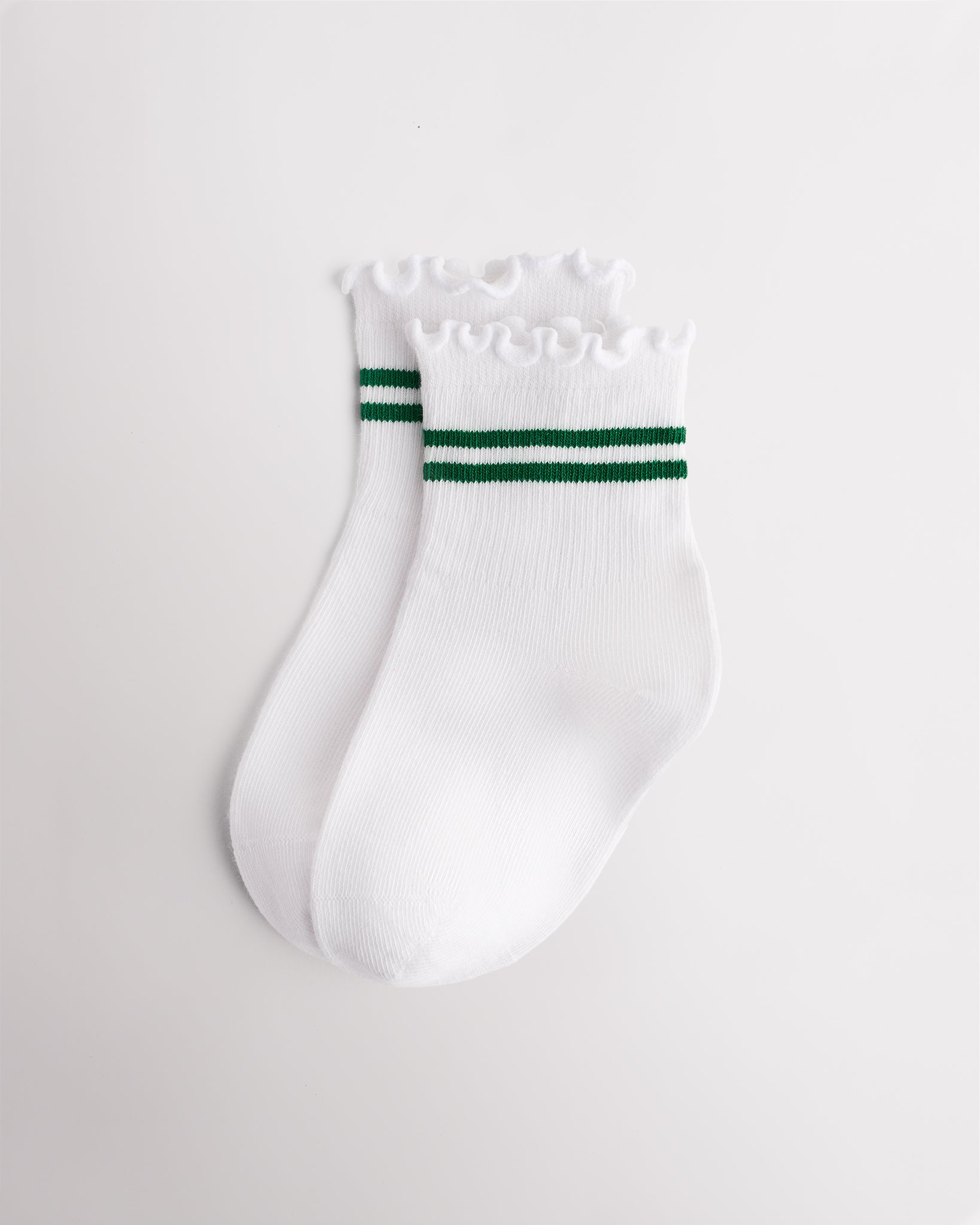 White kids socks with green sporty stripes, ribbed cuffs, and lettuce-edge ruffle trim
