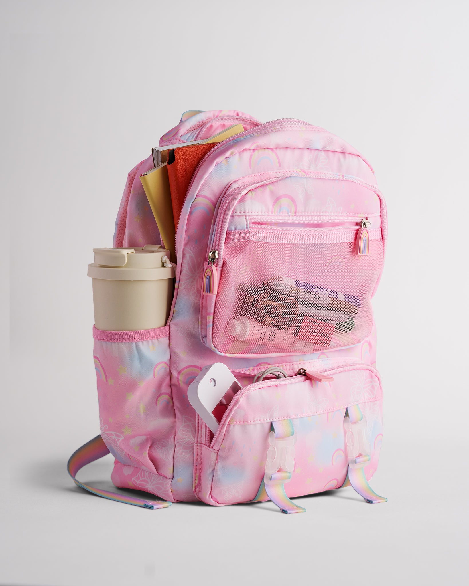 Pink Stelle backpack for kids packed with school and travel essentials, featuring side pocket, front mesh pocket, and zipper compartments.