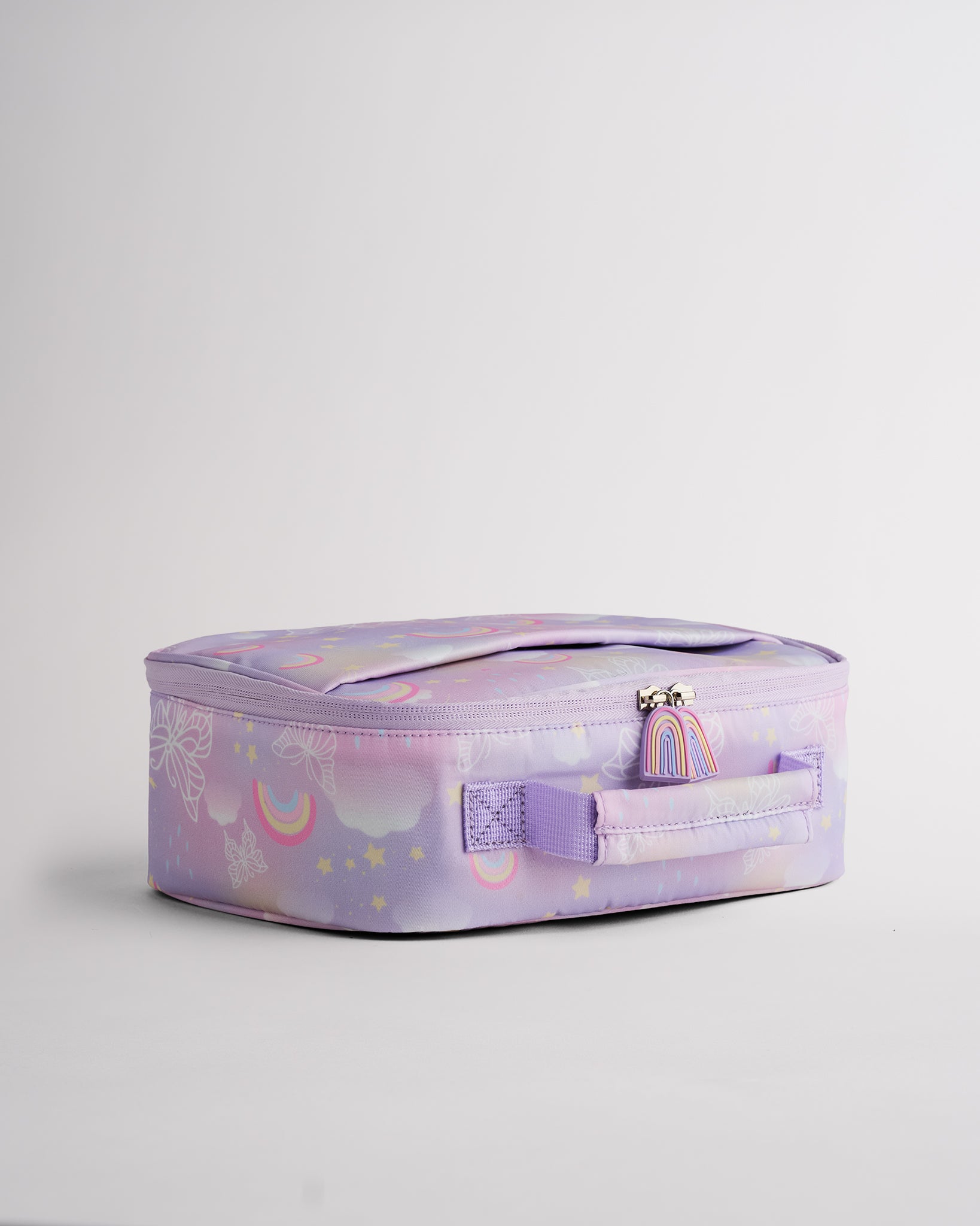 Side view of lavender Stelle lunch bag with rainbow zipper pulls, soft-sided shape, and easy-carry handle.