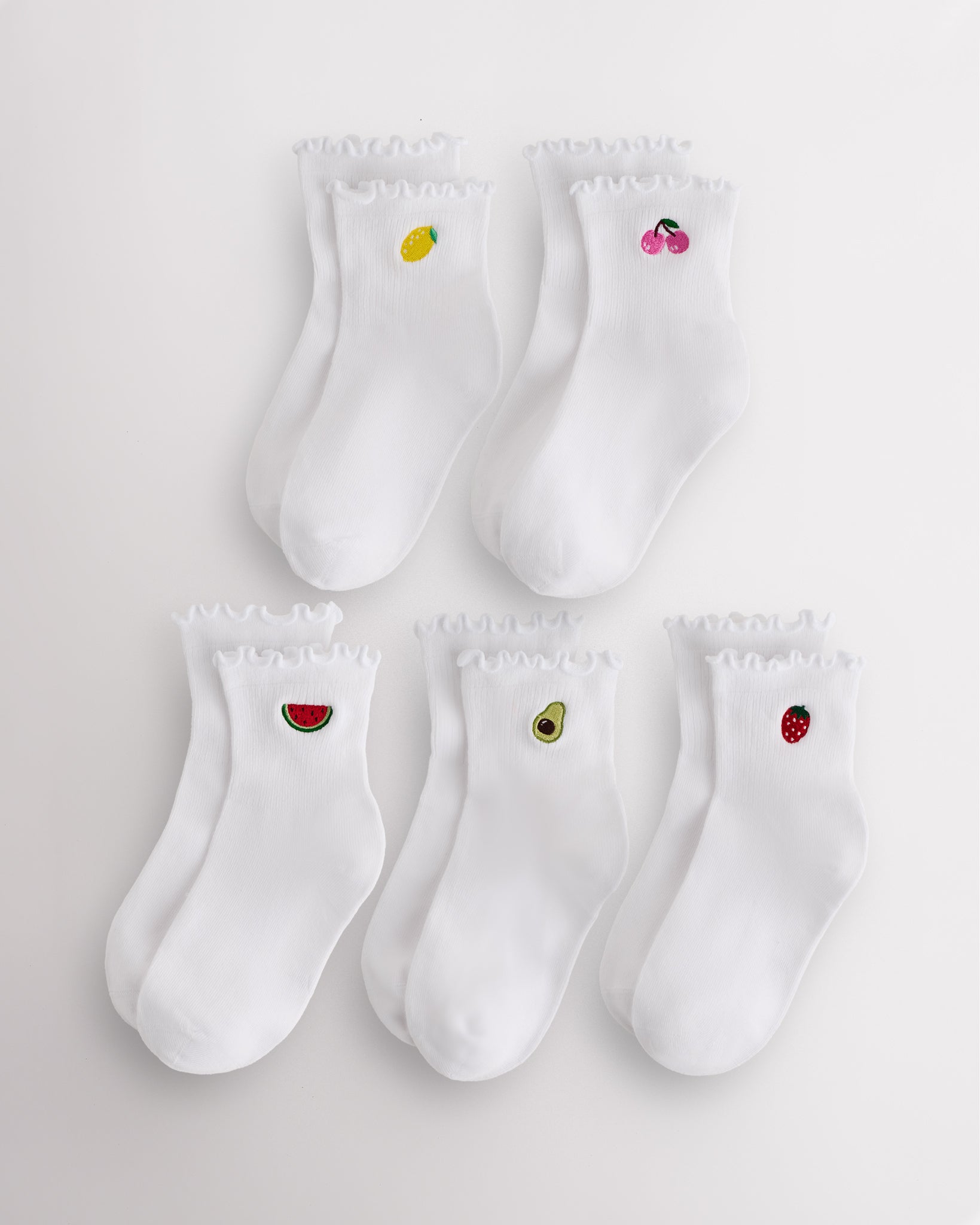 Five-pack white kids ruffle socks with embroidered fruit motifs, lettuce-edge trim, ribbed crew length, and shaped heel.