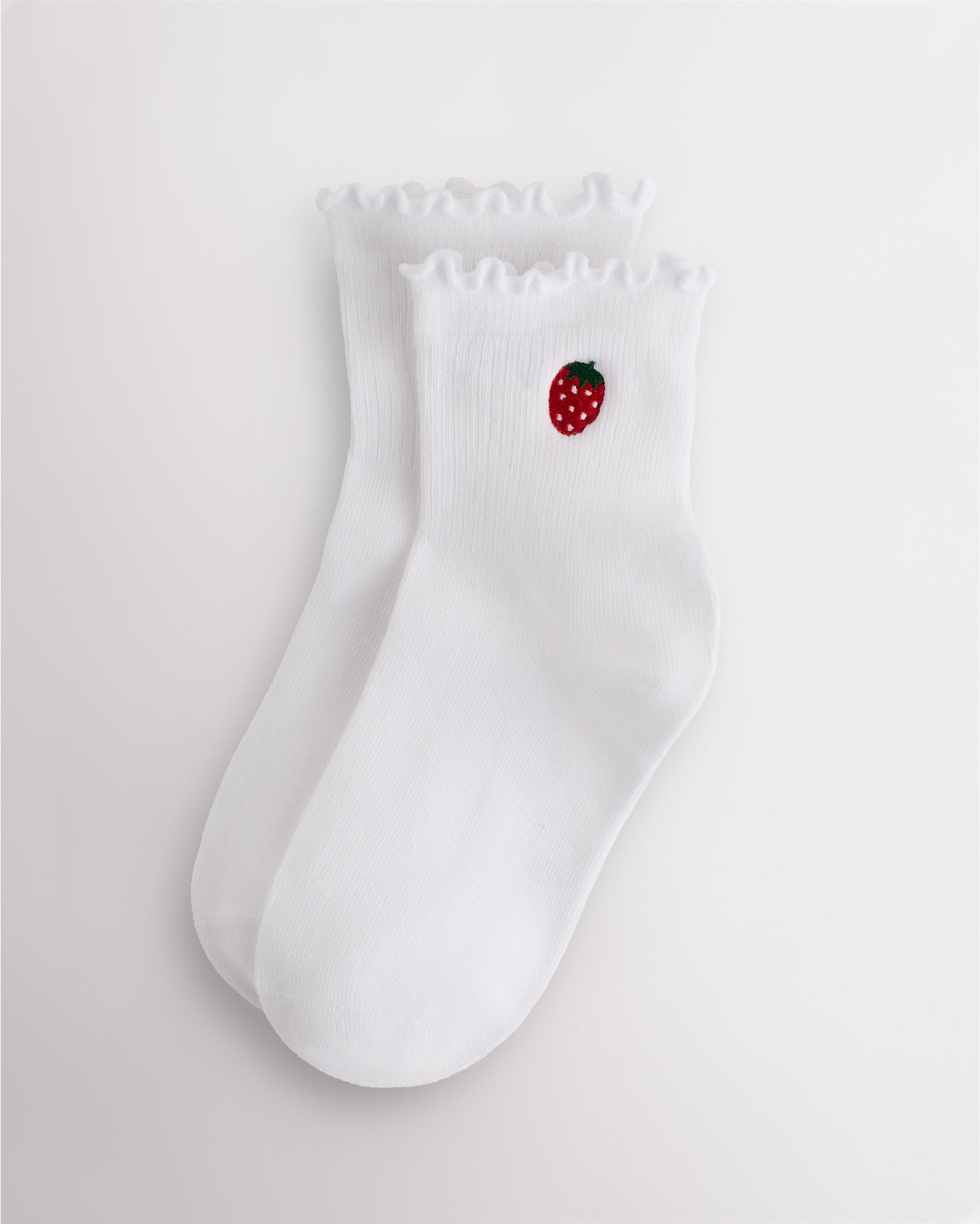 White kids ruffle socks with strawberry embroidery, lettuce-edge trim, ribbed crew length, and everyday wear design.