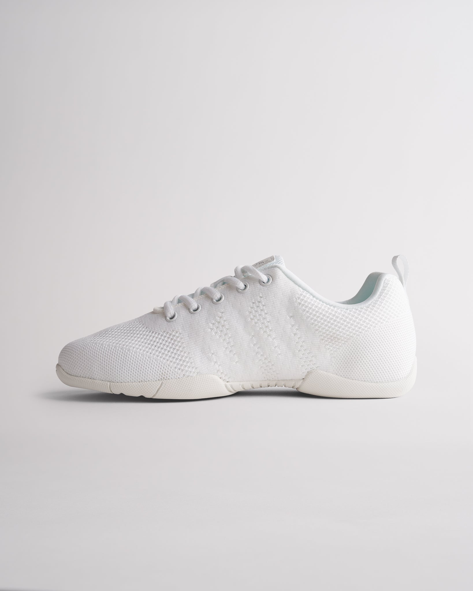 White cheerleading shoes with lace-up design and adaptive knit upper for secure fit