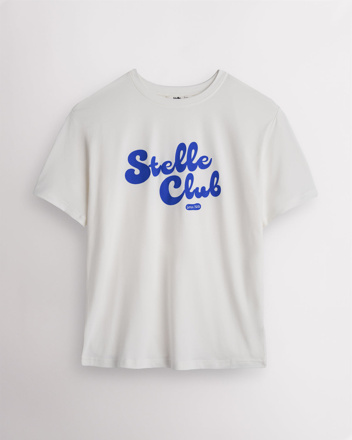 White Stelle oversized T-shirt with a blue Stelle Club graphic, laid flat on a grey background.