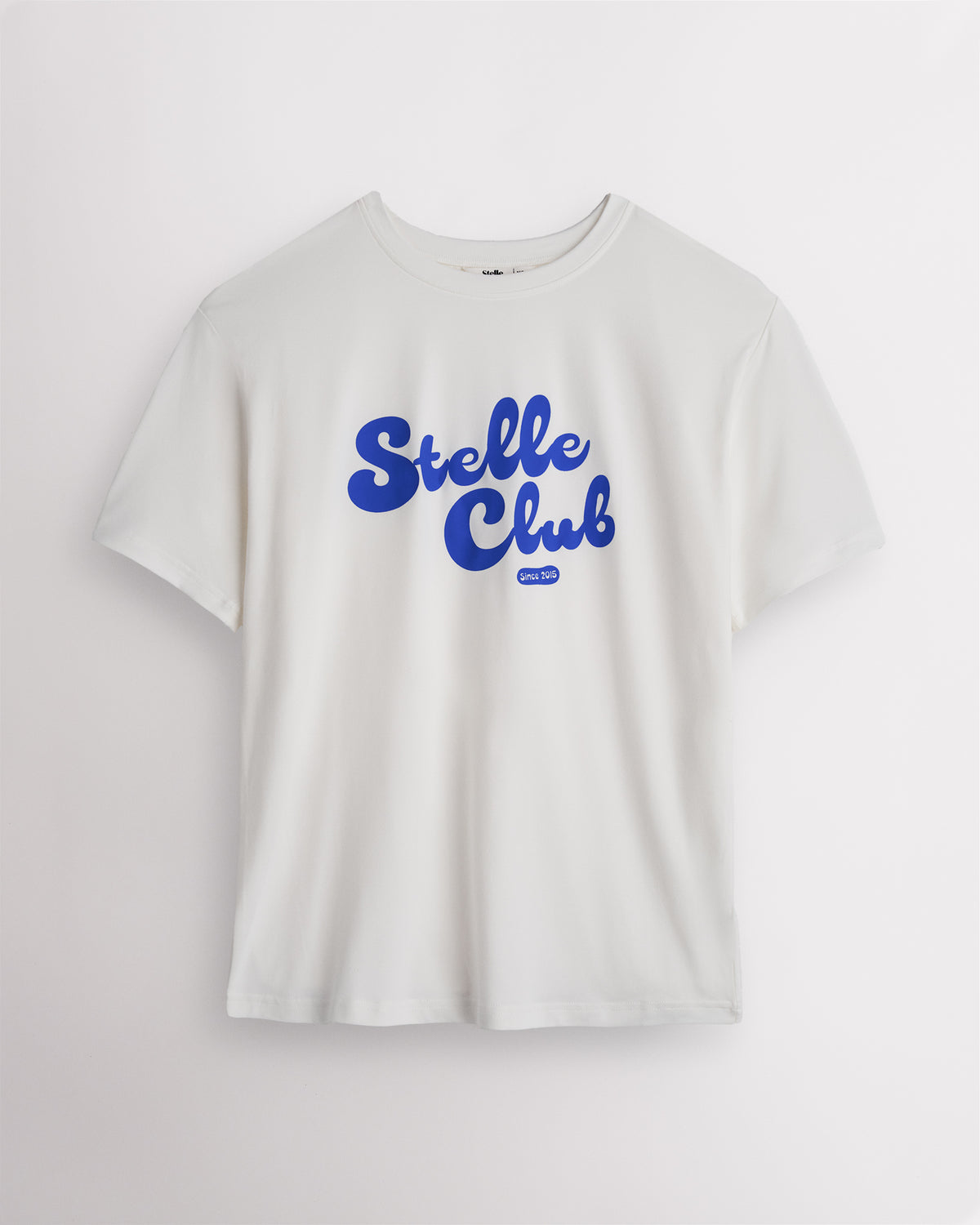 White Stelle oversized T-shirt with a blue Stelle Club graphic, laid flat on a grey background.