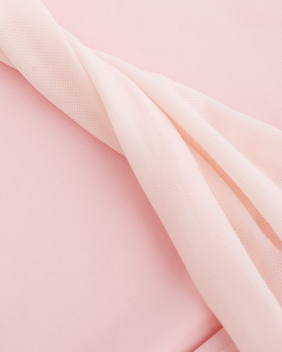 Close-up of Ballet Pink performance leotard showing soft stretch fabric and twisted mesh back detail.