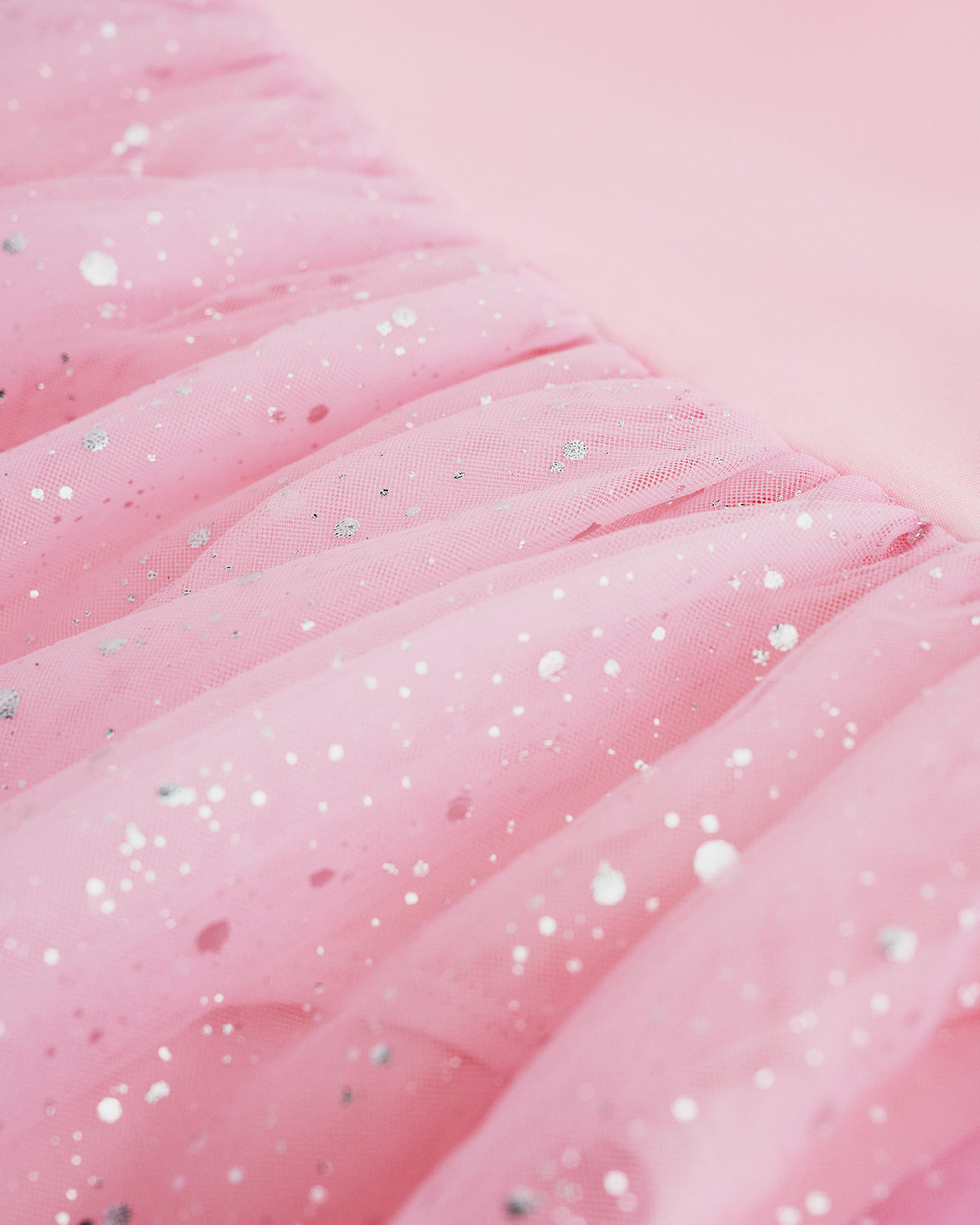 Close-up of Ballet Pink mesh skirt showing soft layered fabric and subtle shimmer details.