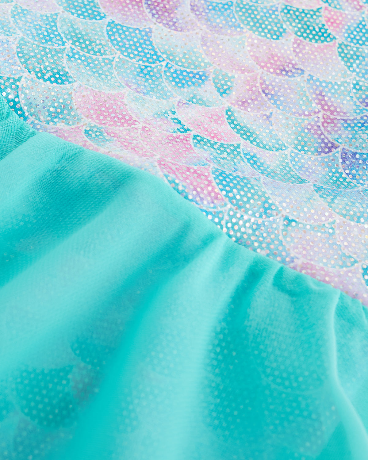 Close-up of Mermaid Sparkle ballet dress showing shimmering mermaid-inspired print and gathered skirt fabric.