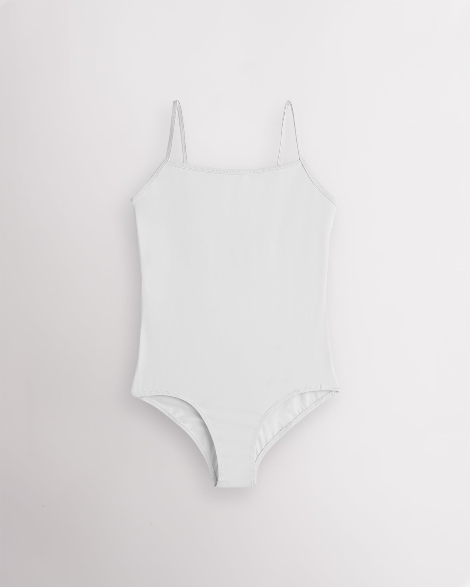 White girls camisole leotard with adjustable spaghetti straps, front lining, and smooth performance fabric.