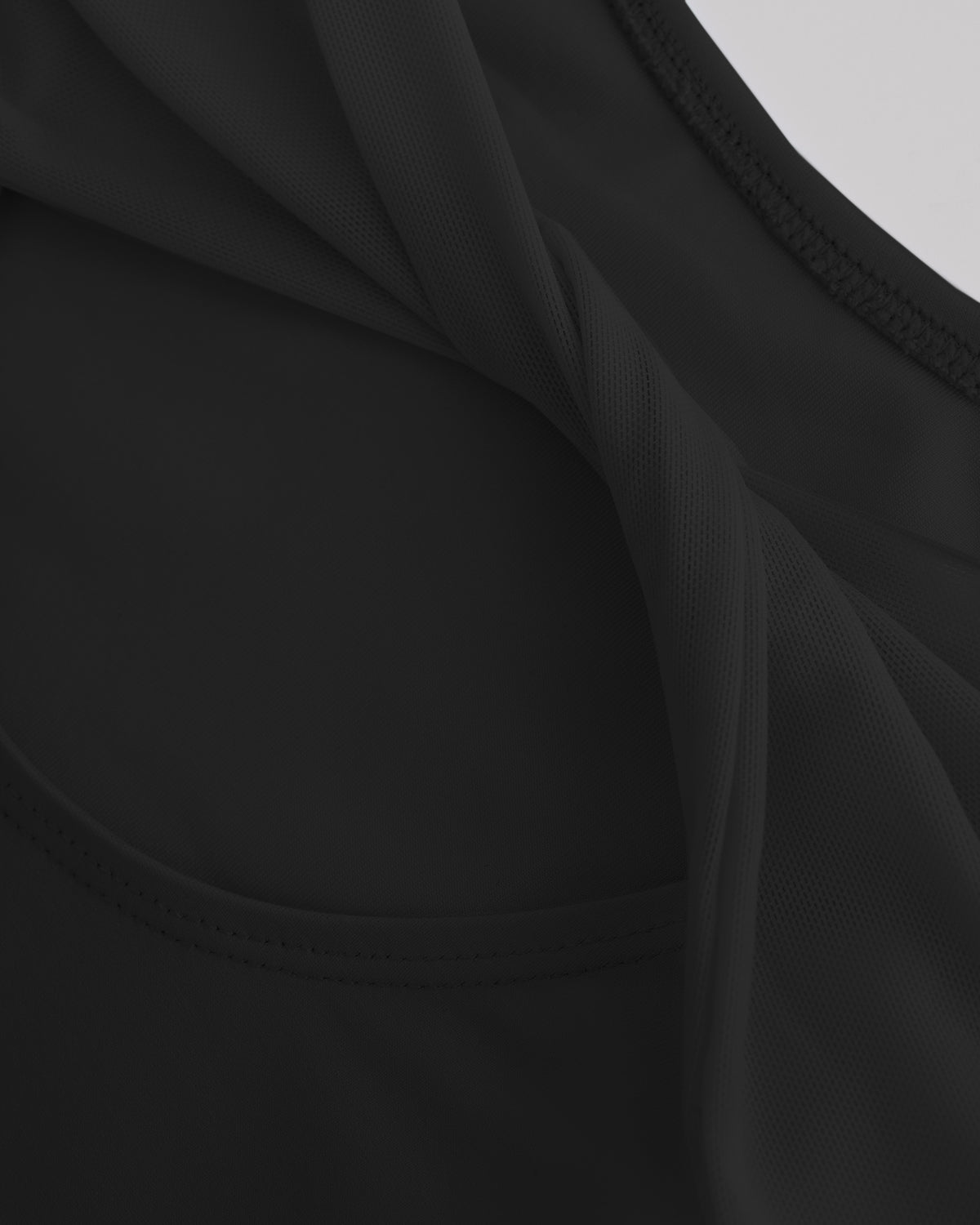 Close-up of Black ballet leotard showing the sheer twisted mesh back fabric and smooth performance material.