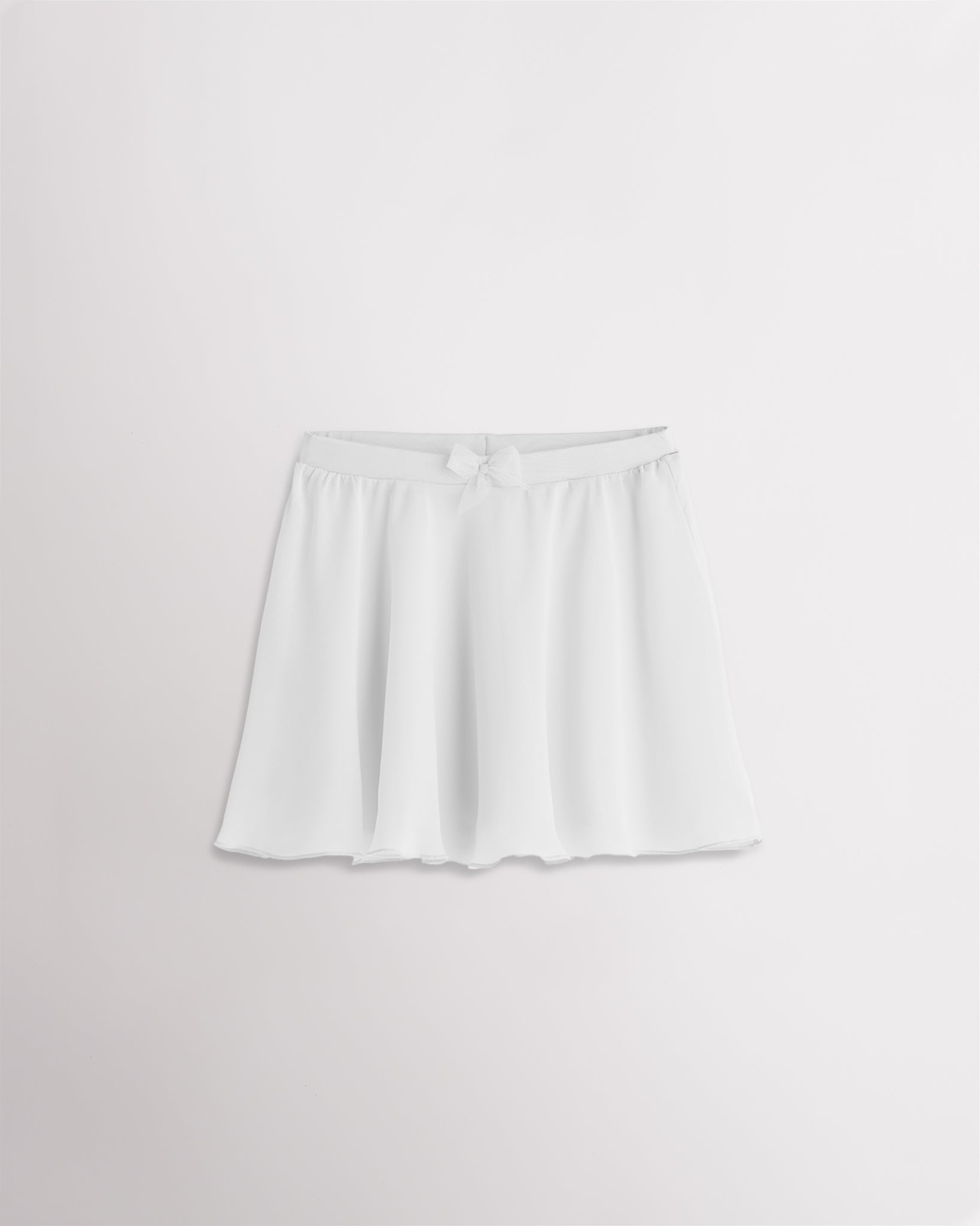 Girls white chiffon ballet dance skirt with a flowy silhouette, elastic waistband, and bow detail at the waist.