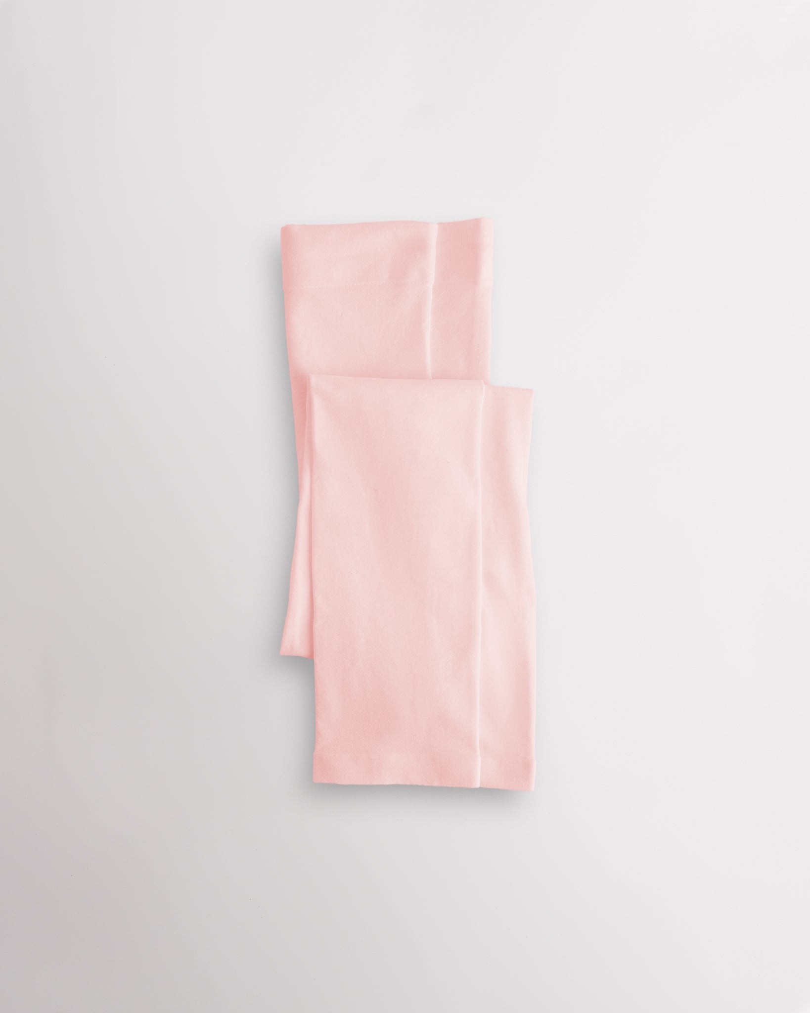 Pink girls microfiber footless dance tights folded flat with elastic waistband and soft fabric for ballet and dance practice.