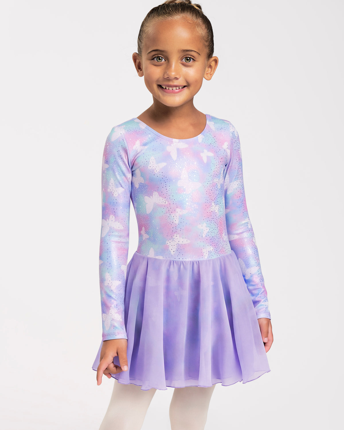 Girl wearing a Magic Flutter long sleeve ballet dress with attached skirt, shimmering print, and ballet tights.