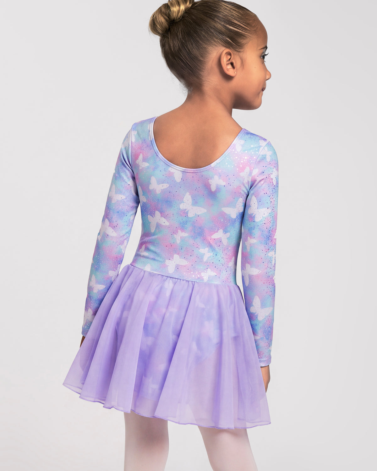Back view of girl wearing a Magic Flutter girls dance dress with long sleeves, scoop back, and attached lavender skirt.