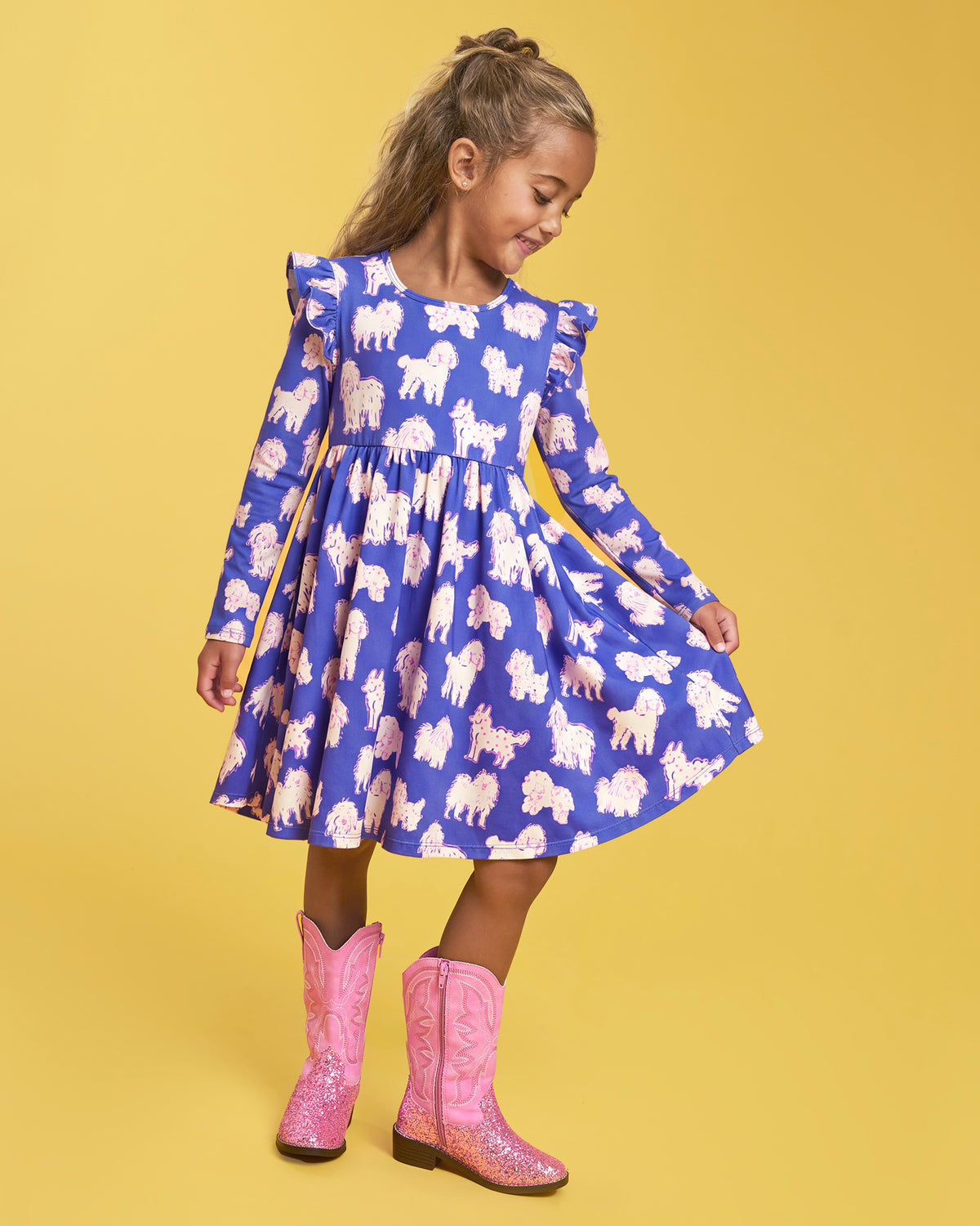 Girl wearing a Charlie Pals on Blue long sleeve dress with ruffle shoulders, gathered waist, A-line shape, and bright pink boots.