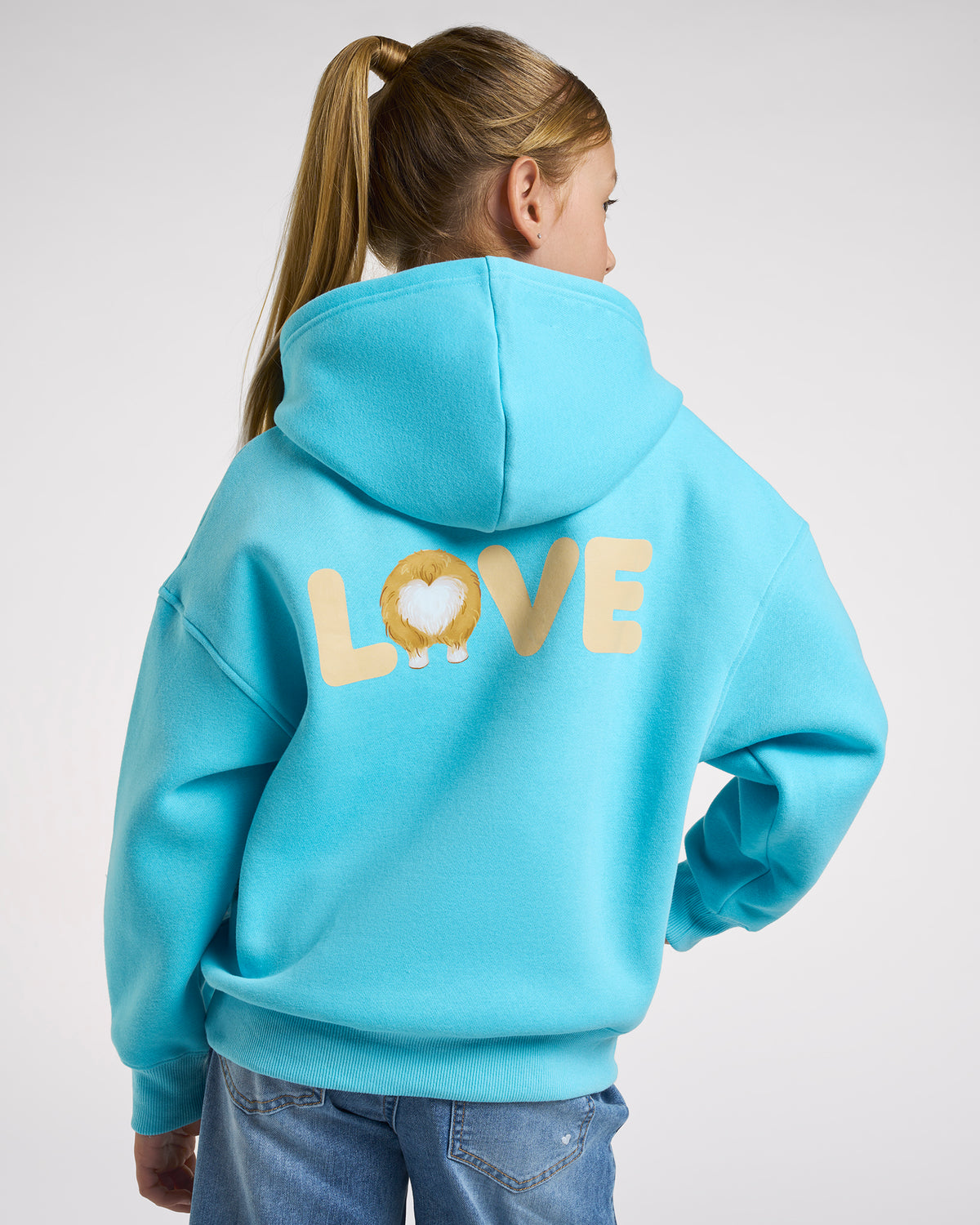 Back view of girl wearing an aqua blue puppy hoodie with relaxed oversized fit and large LOVE corgi graphic on the back.