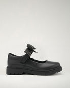 A black Mary Jane shoe with a detachable bow accessory, designed for girls.