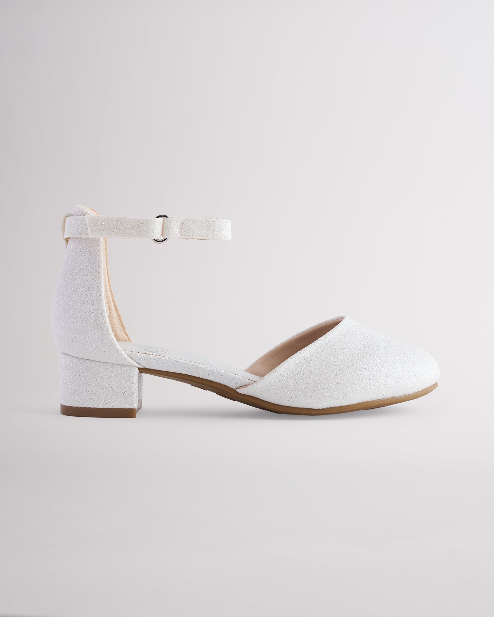 Girls’ white glitter dress shoes with a low block heel and ankle strap.