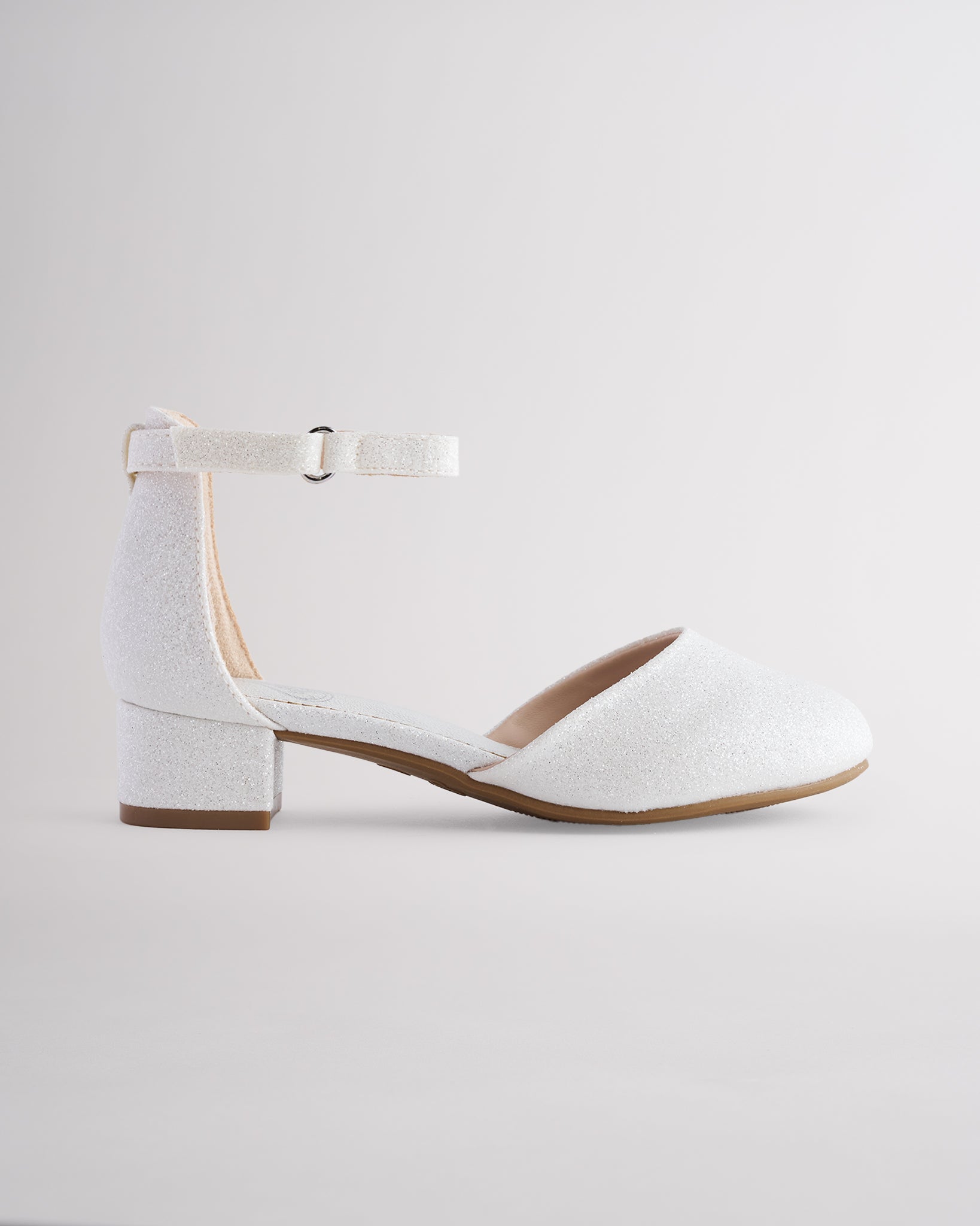 Girls’ white glitter dress shoes with a low block heel and ankle strap.