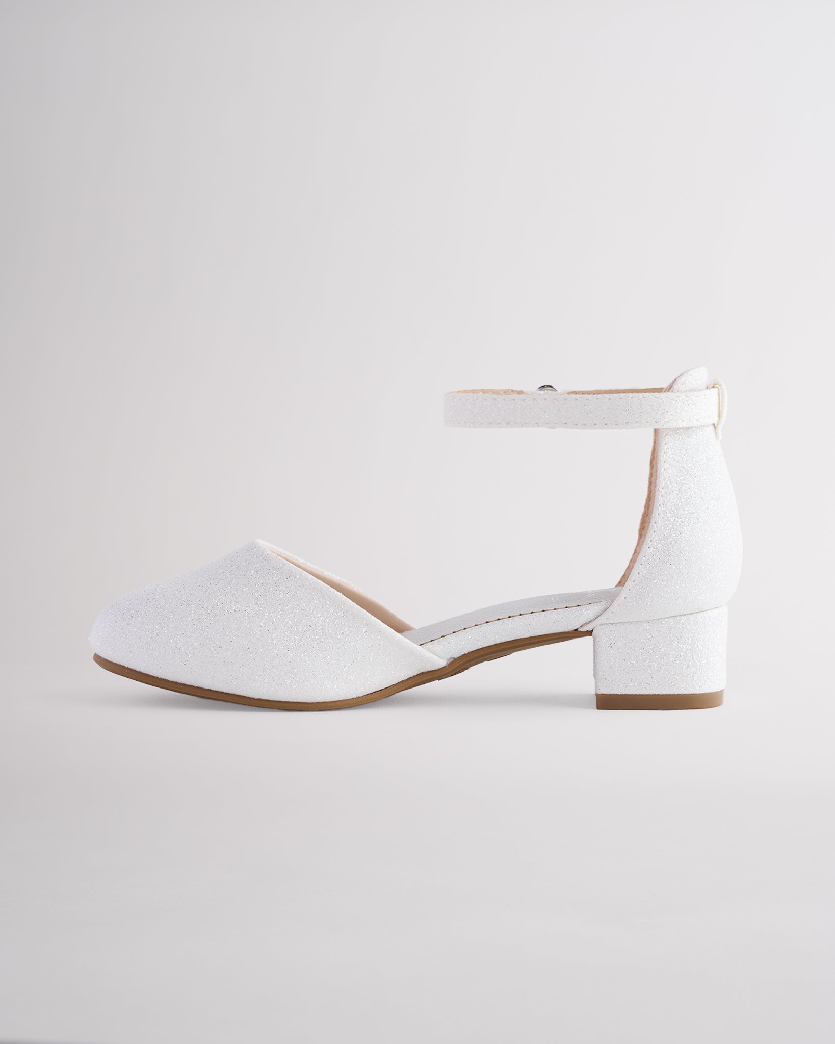Girls’ white glitter dress shoes with a low block heel and ankle strap.