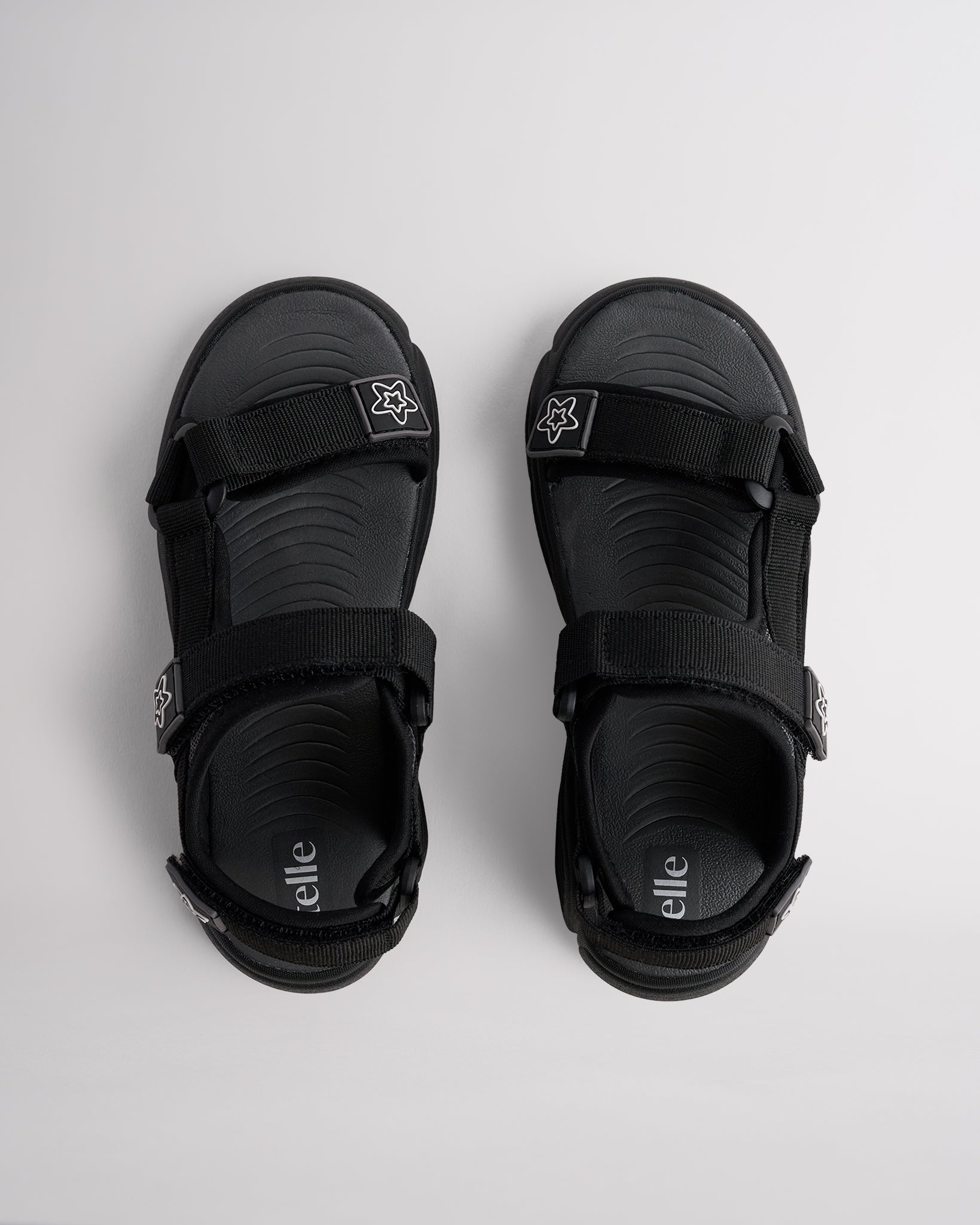 Top view of black sandals for kids with three adjustable straps and textured footbed