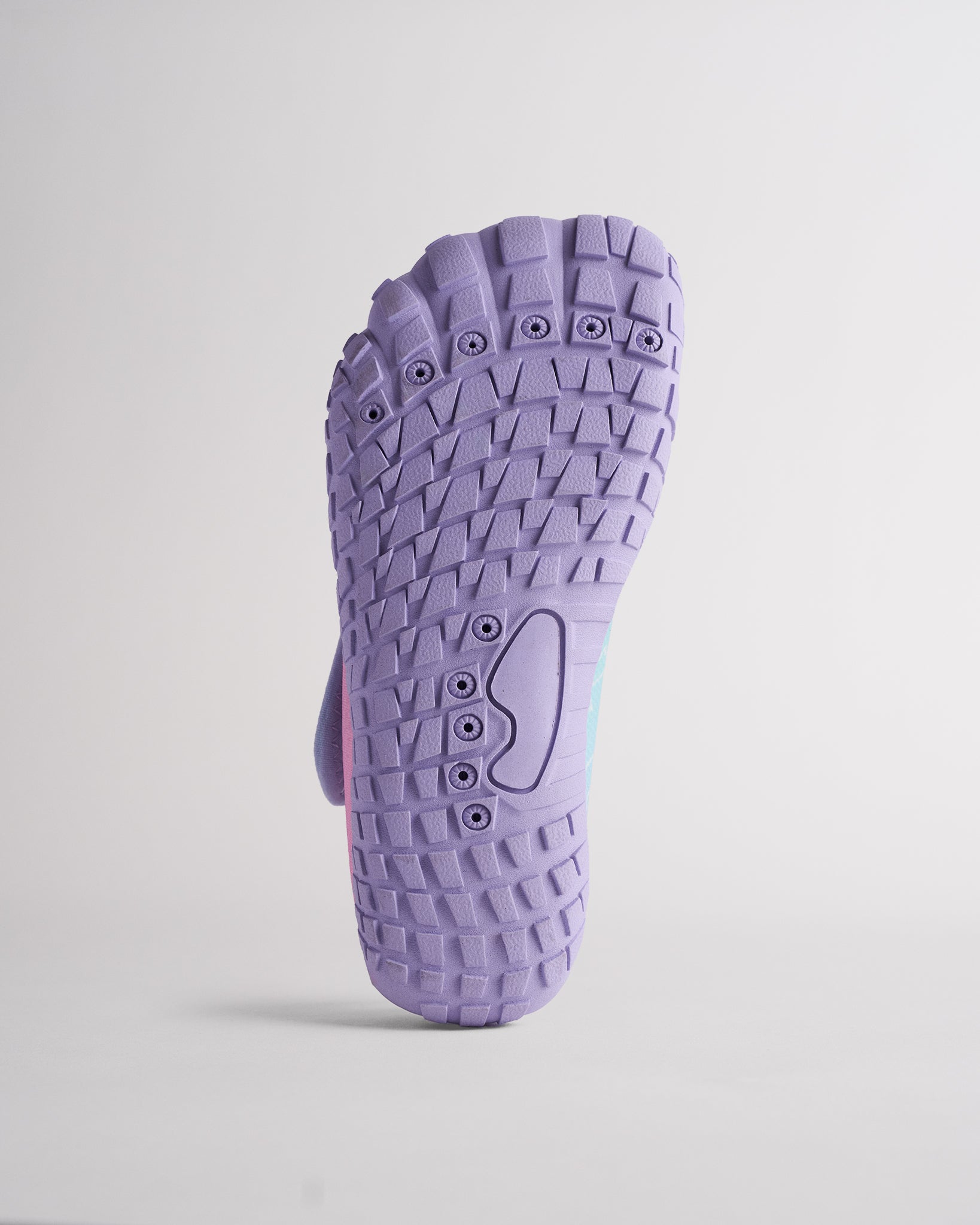 Bottom view of Kids StelleMesh water shoe with purple traction outsole and drainage holes for water activities.
