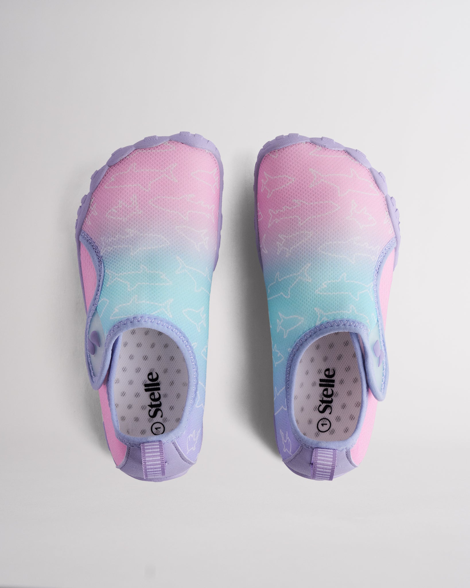 Pair of Kids StelleMesh slip-on water shoes with roomy toe box, mermaid ombre print, and adjustable velcro closure.