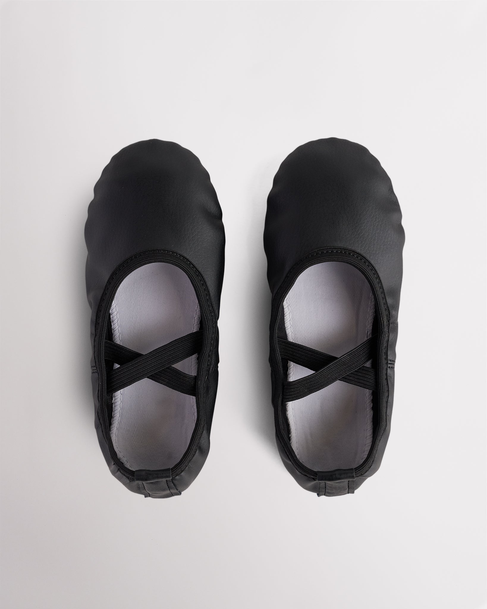 Pair of black kids vegan leather ballet shoes with cross elastic straps, soft lining, and easy-clean PU leather upper.