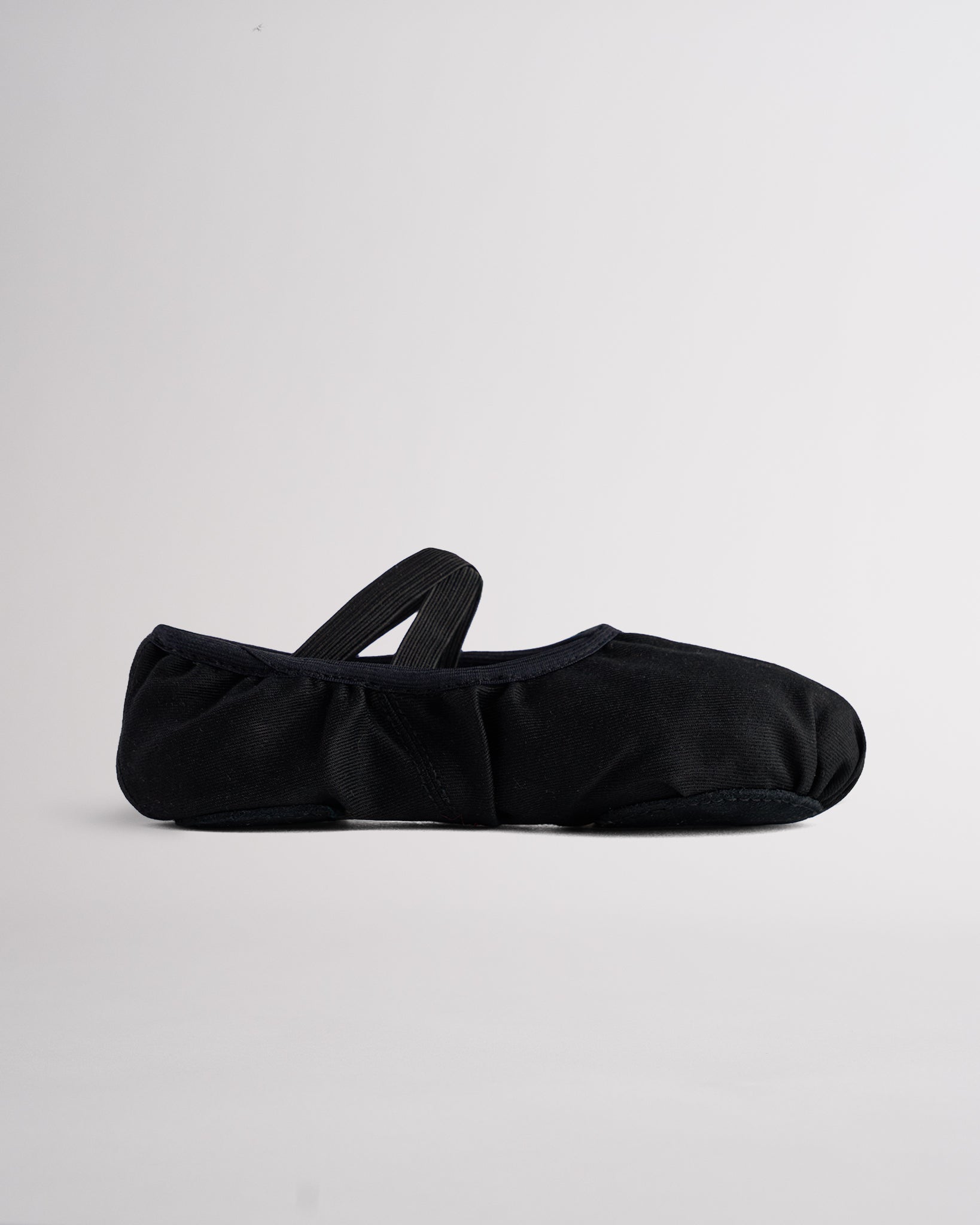 Black kids stretch canvas split sole ballet shoe with elastic strap, lightweight canvas upper, and snug ballet slipper fit.