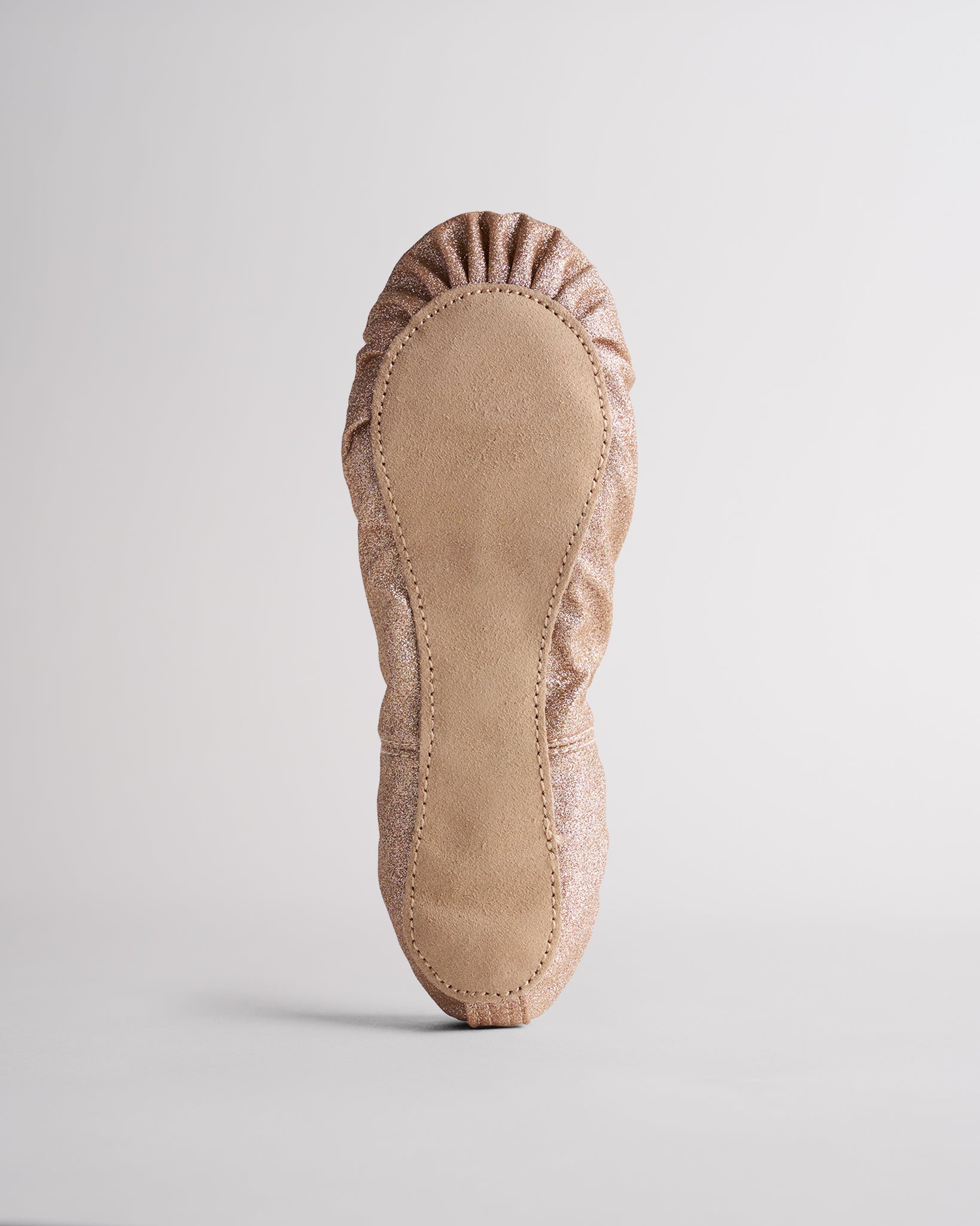 Kids gold glitter ballet shoes with suede sole, bottom view