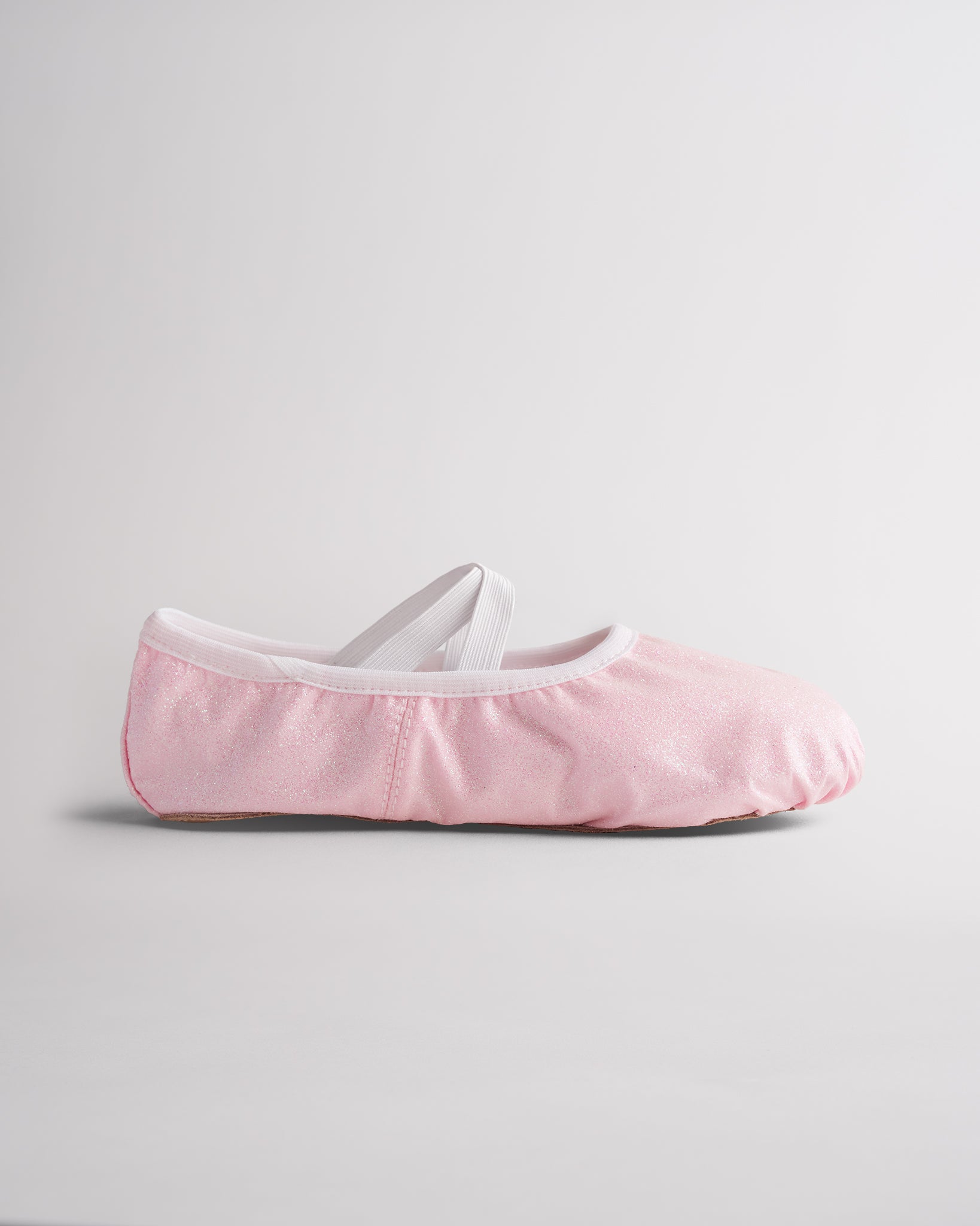 Kids glitter ballet shoes in pink glitter with elastic straps, side view