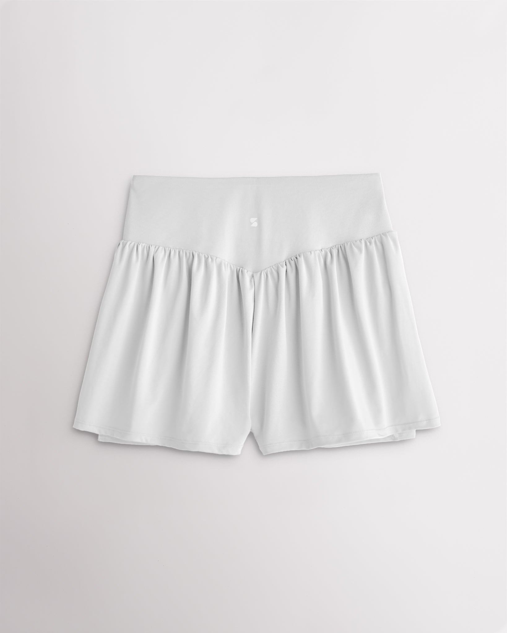 Back view of women’s white high waisted athletic shorts with a flowy layered design and V-contour back seam.