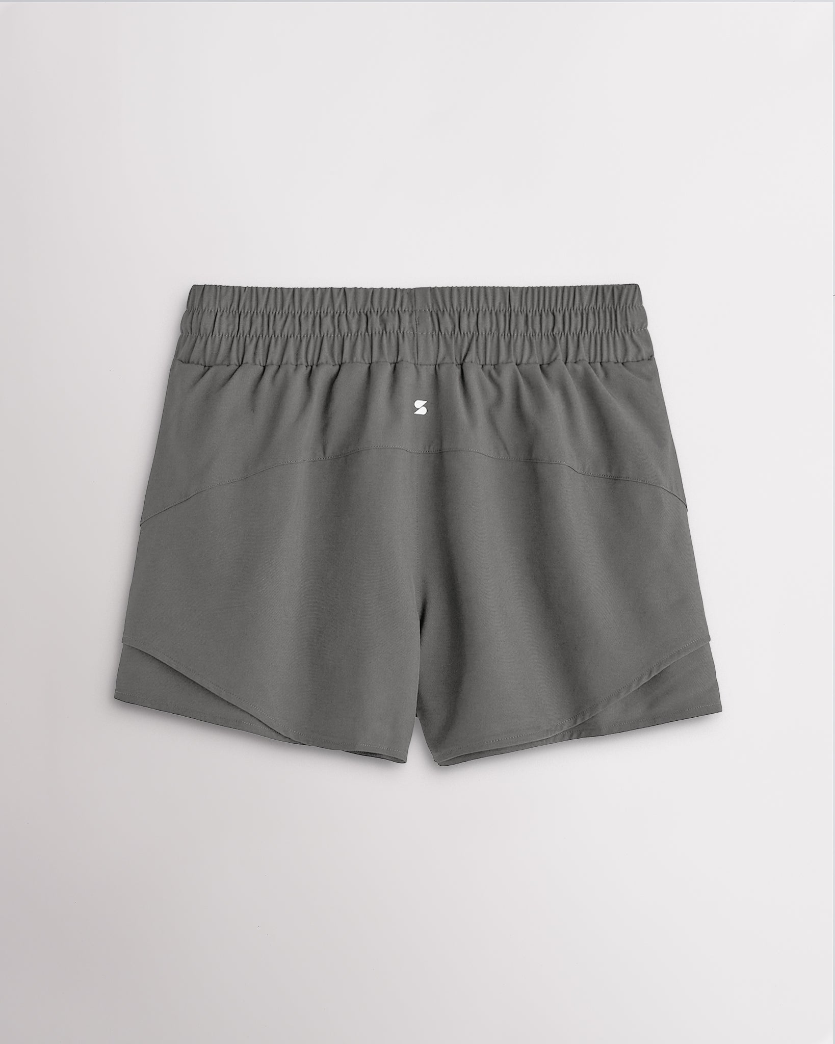Back view of women’s smoke grey running shorts with a high-rise elastic waistband and layered hem design.