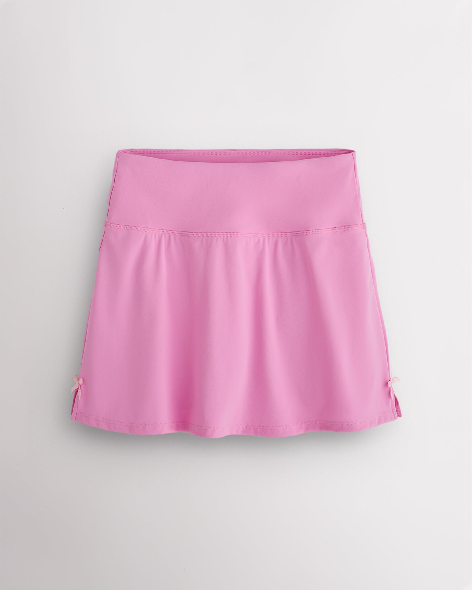 Cotton Candy Stelle classic tennis skirt with a high-waisted fit, slightly flared silhouette, side slits, and bow ribbon details.