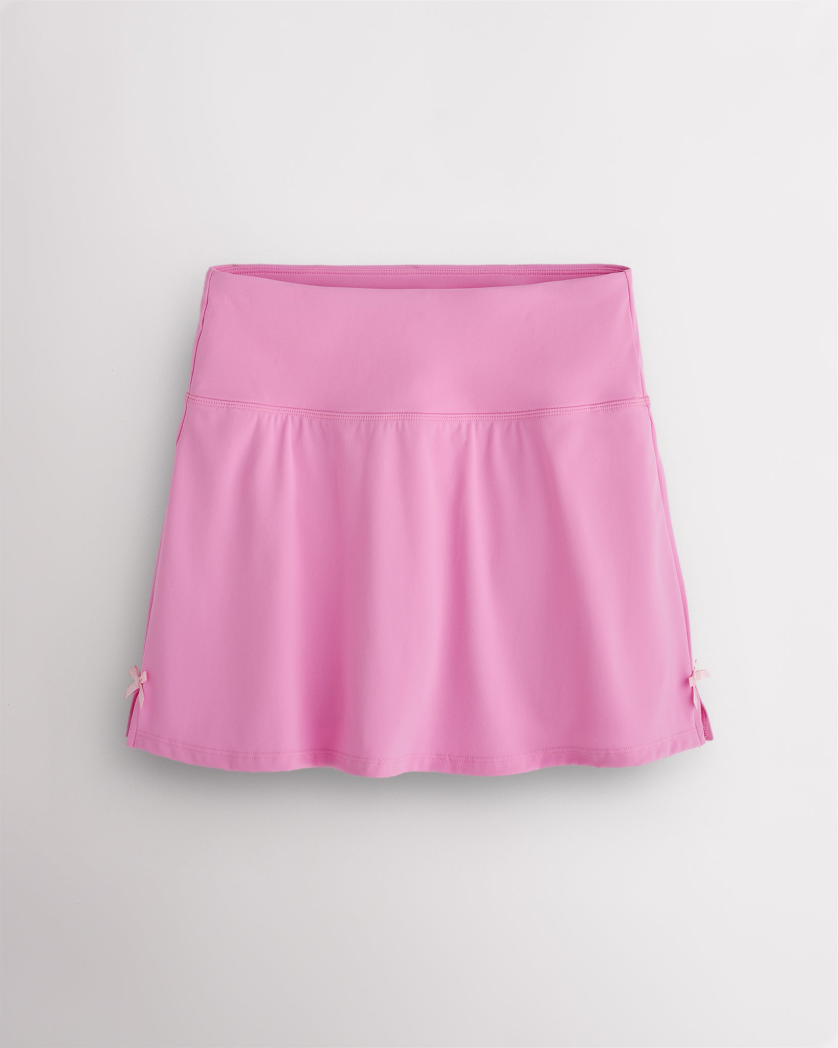 Cotton Candy Stelle classic tennis skirt with a high-waisted fit, slightly flared silhouette, side slits, and bow ribbon details.