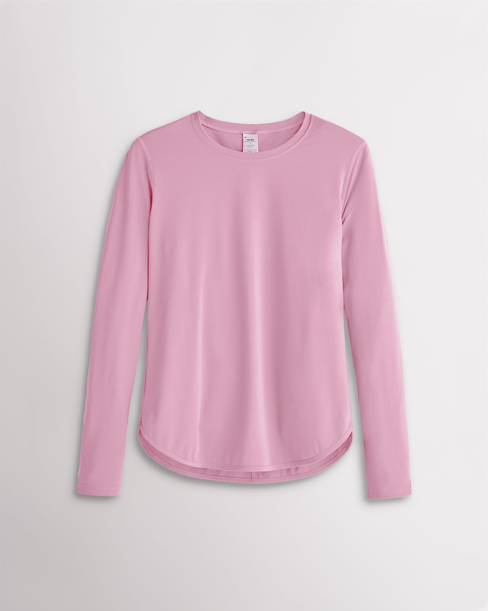 Women’s petal pink UPF 50+ long sleeve sun protection shirt with curved hem and lightweight breathable fabric.