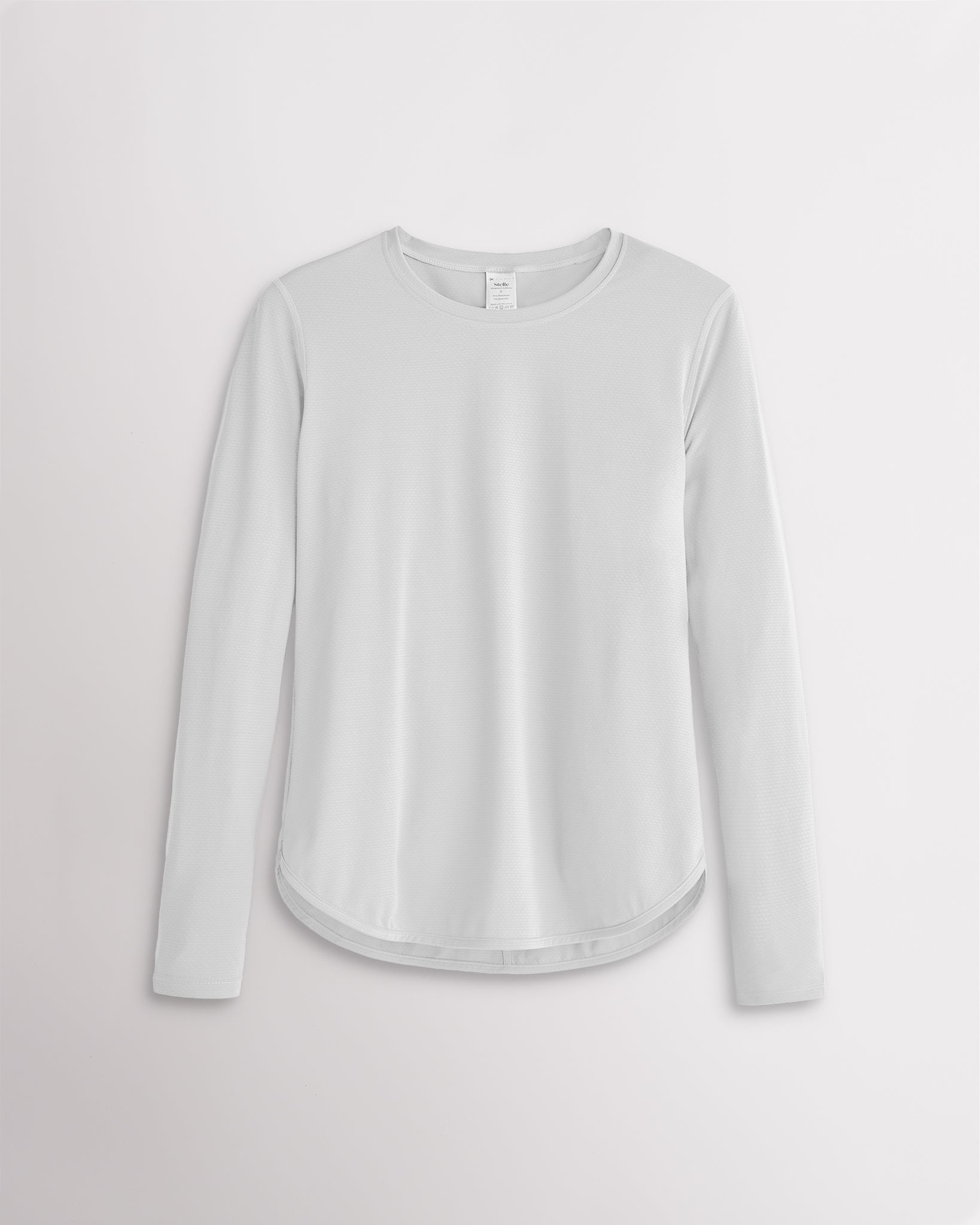 Women’s white UPF 50+ long sleeve sun protection shirt with curved hem and lightweight breathable fabric.