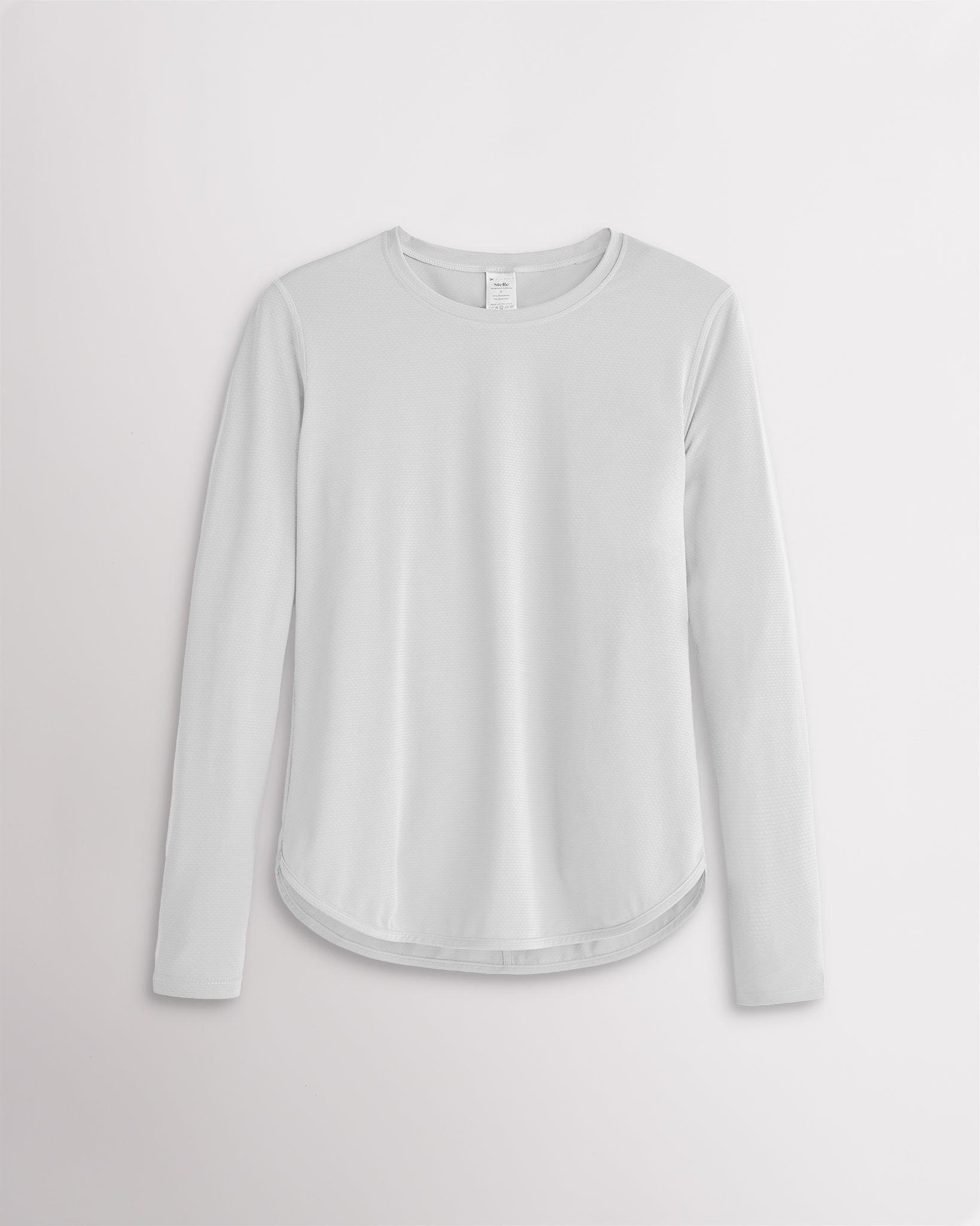 Women’s white UPF 50+ long sleeve sun protection shirt with curved hem and lightweight breathable fabric.