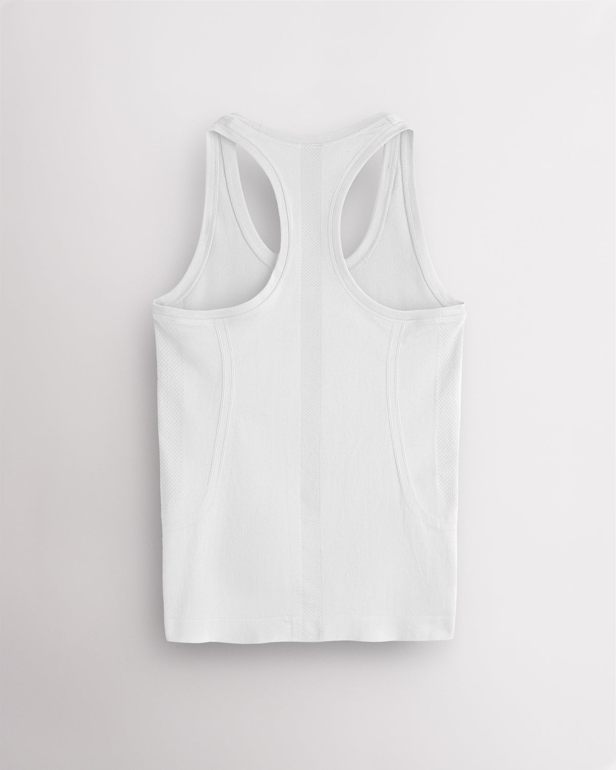 Back view of the white Stelle seamless tank top, laid flat to show the racerback straps.