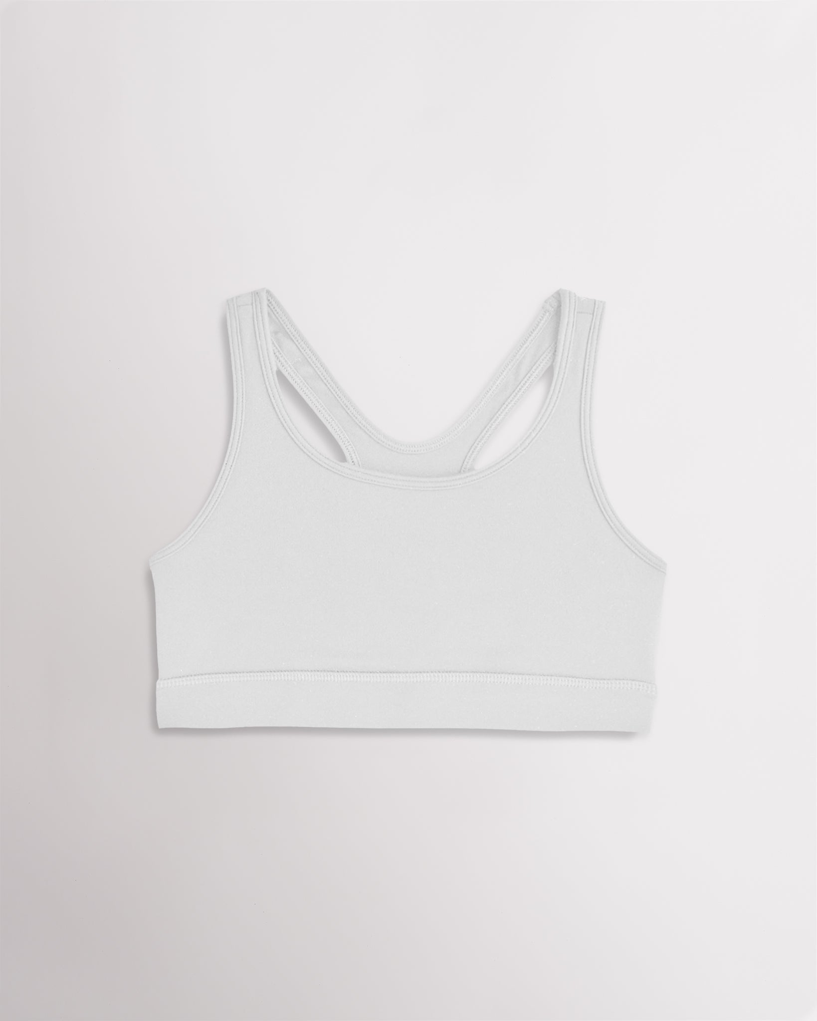 White racerback sports bra for girls with wide straps and a smooth band.
